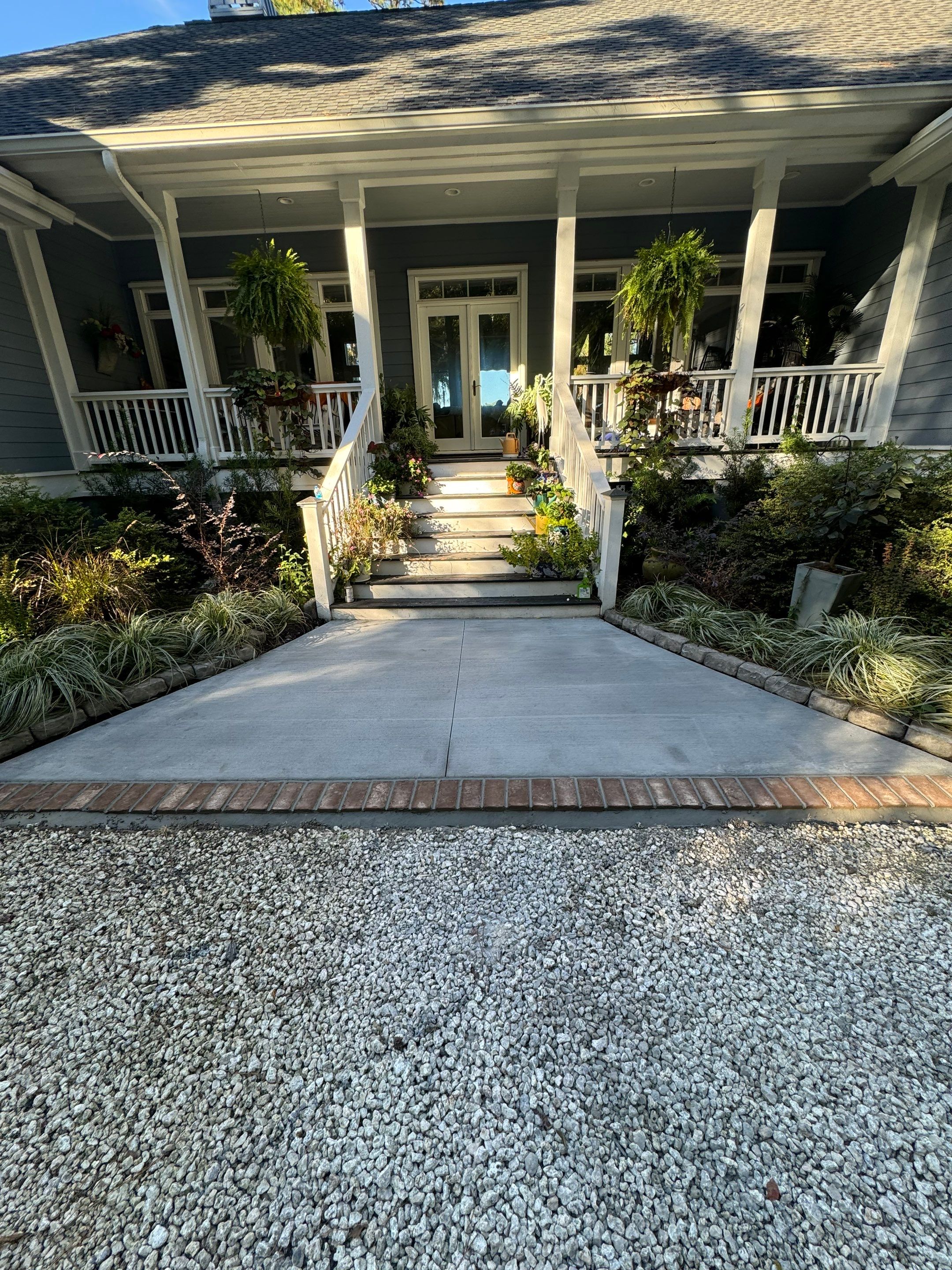 Concrete Driveway and Patio Installation With Decorative Brick Borders by Lowcountry Scapes, LLC