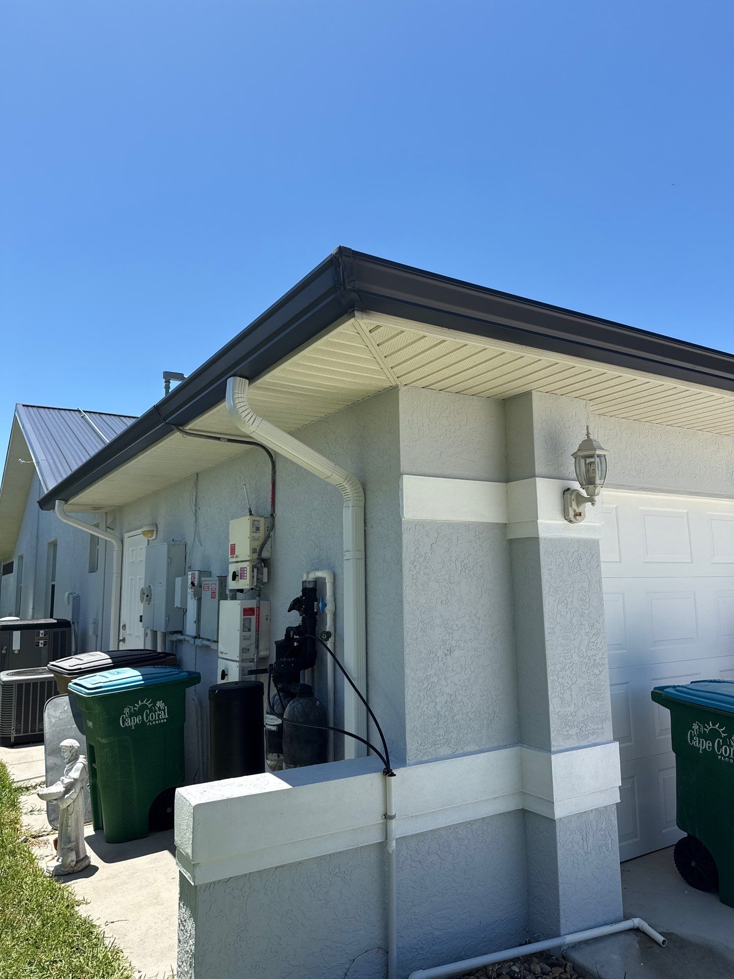 Black Seamless Gutters and White Downspouts in Cape Coral FL by Gutter Professors