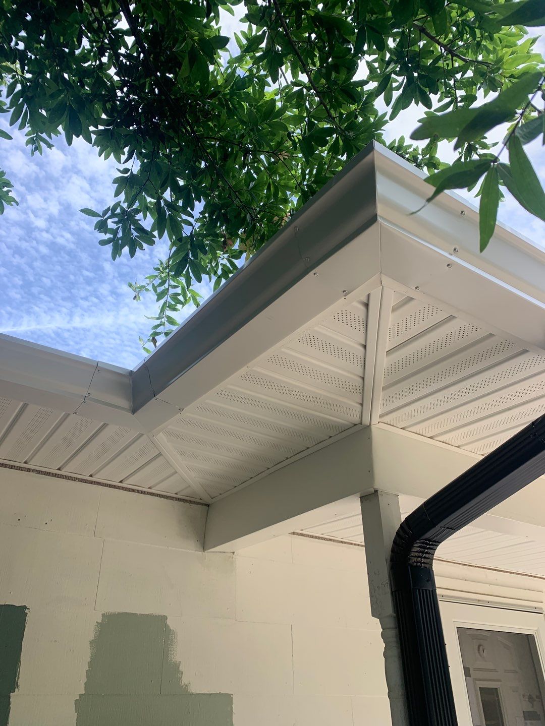 White Seamless Gutters and Black Downspouts by Gutter Professors