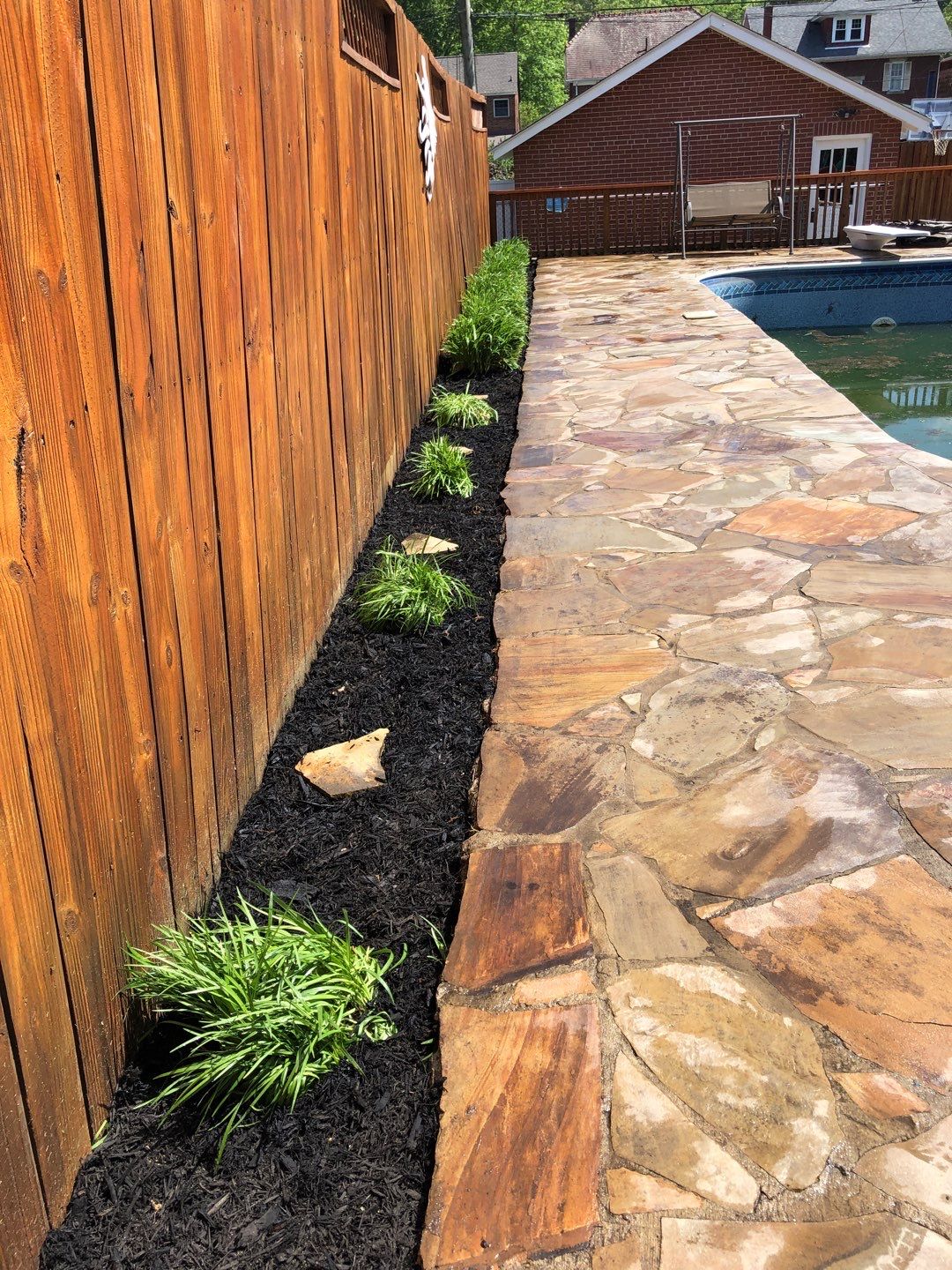 Liriope grasses, mulch and stone pavers by GrassBusters, Inc.