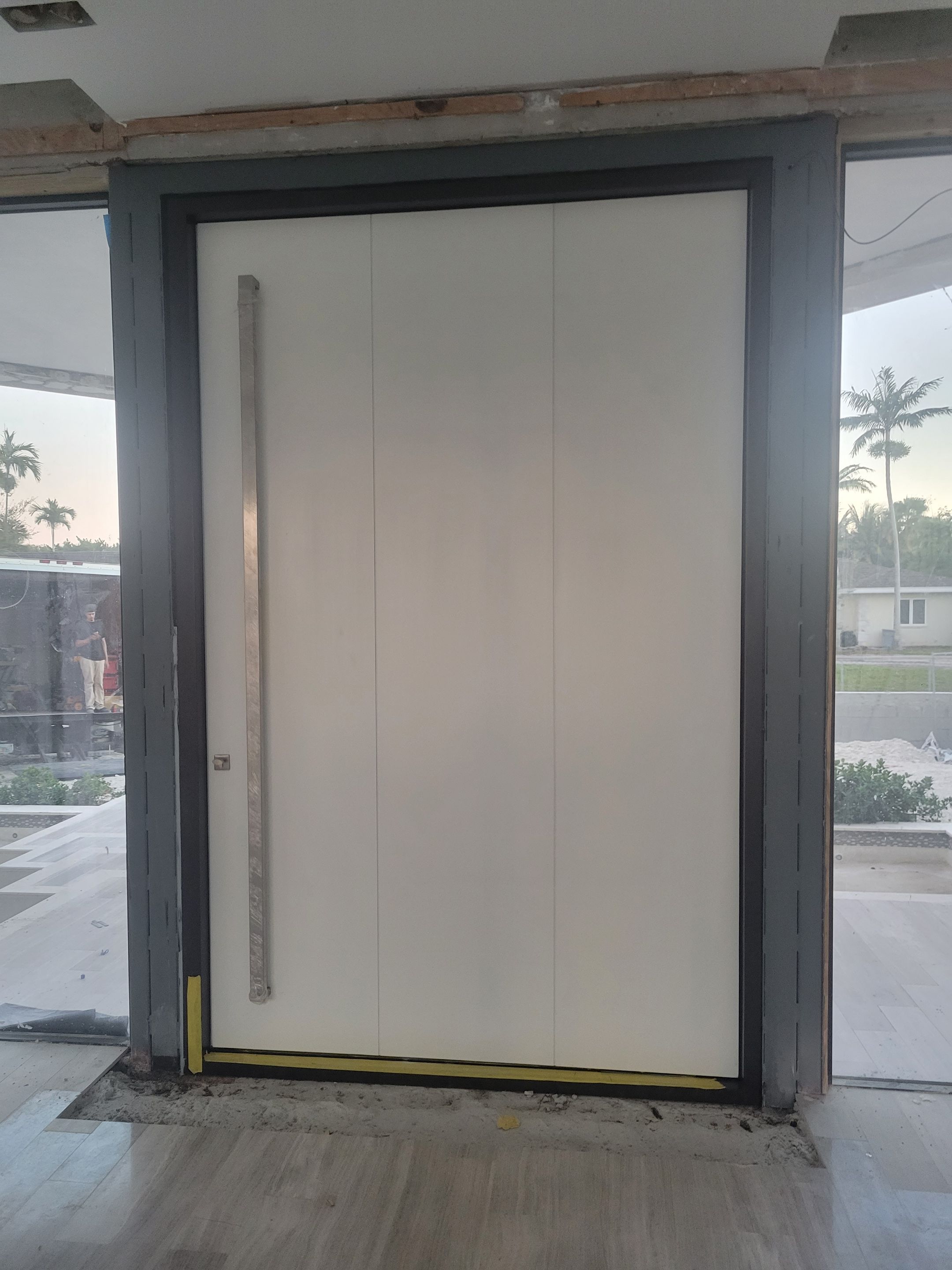 Custom Material Pivot Door installation by Impact Precious Wood Inc.