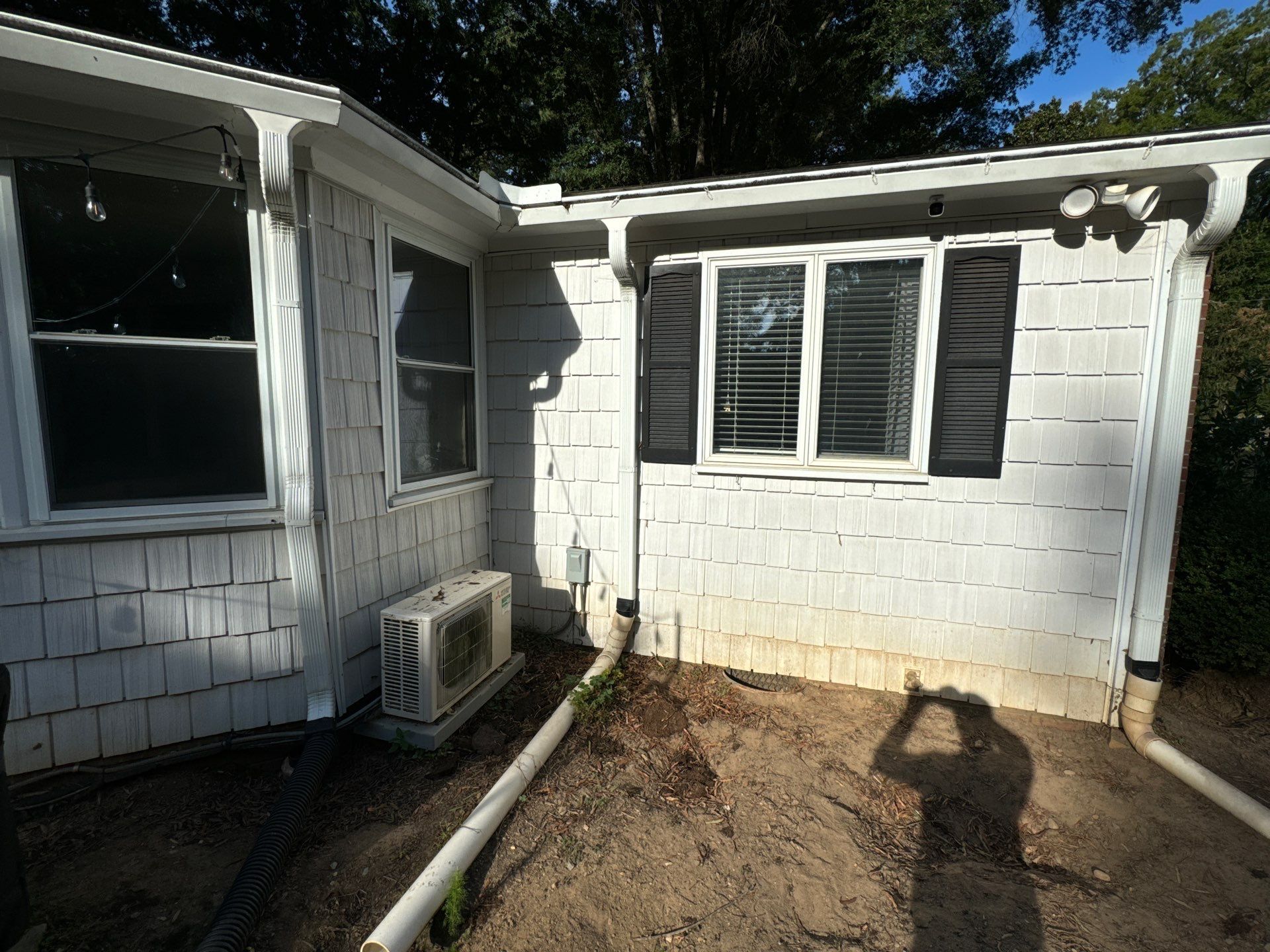 the service shows cleaning of a house exterior including siding air conditioning unit and surrounding areas to remove dirt and grime