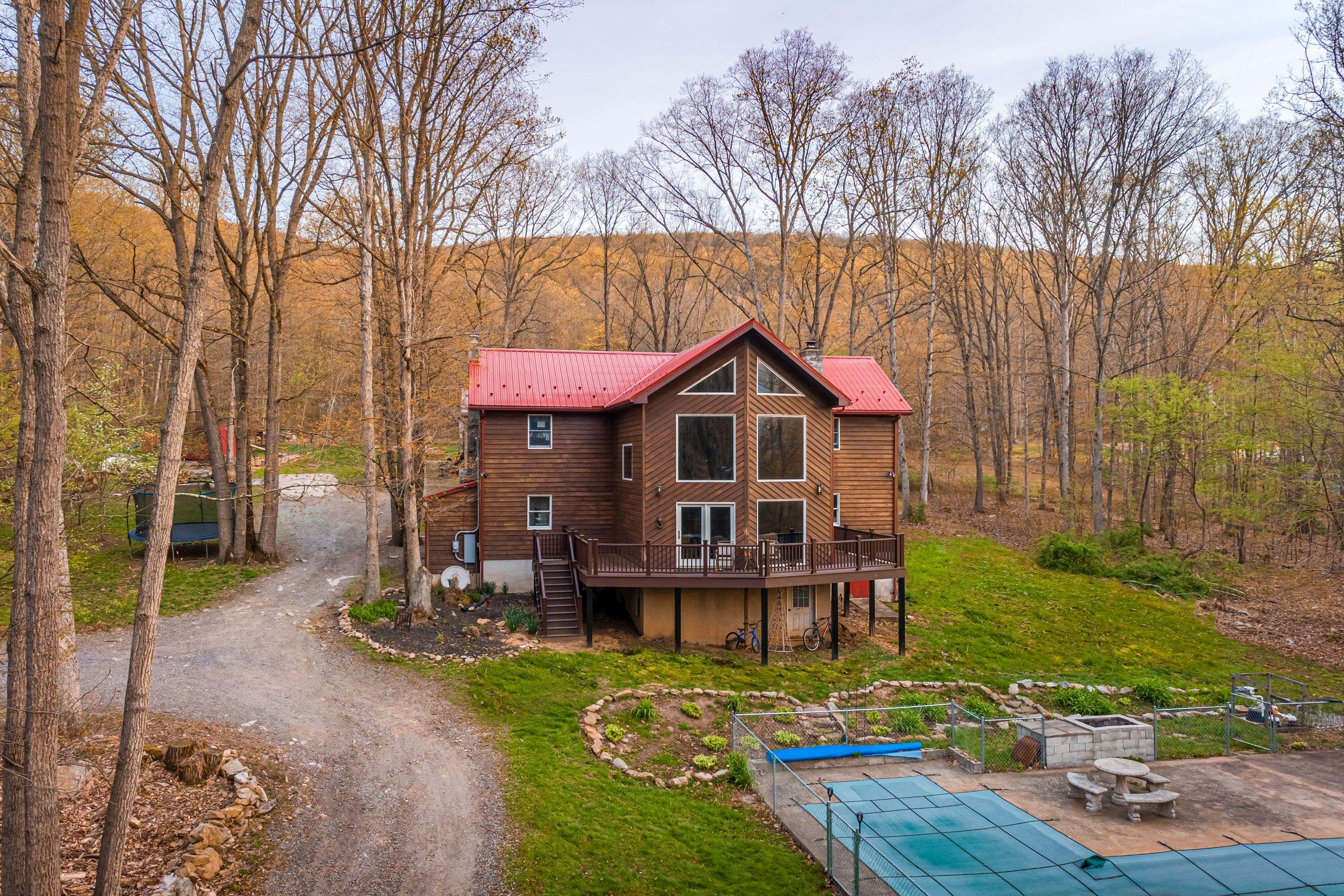 Metal Roof-barn red and new deck by Esh Builders