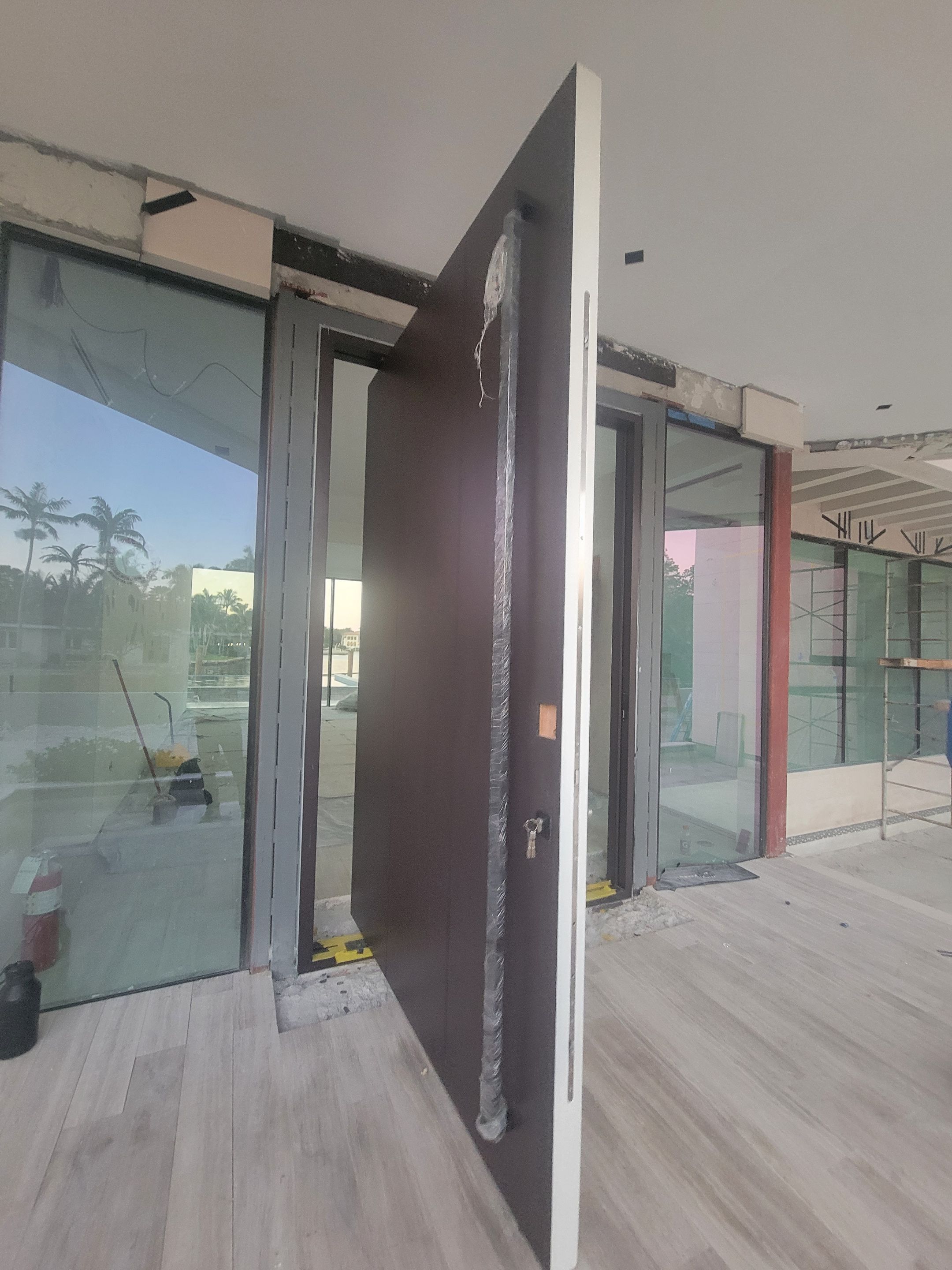 Custom Material Pivot Door installation by Impact Precious Wood Inc.