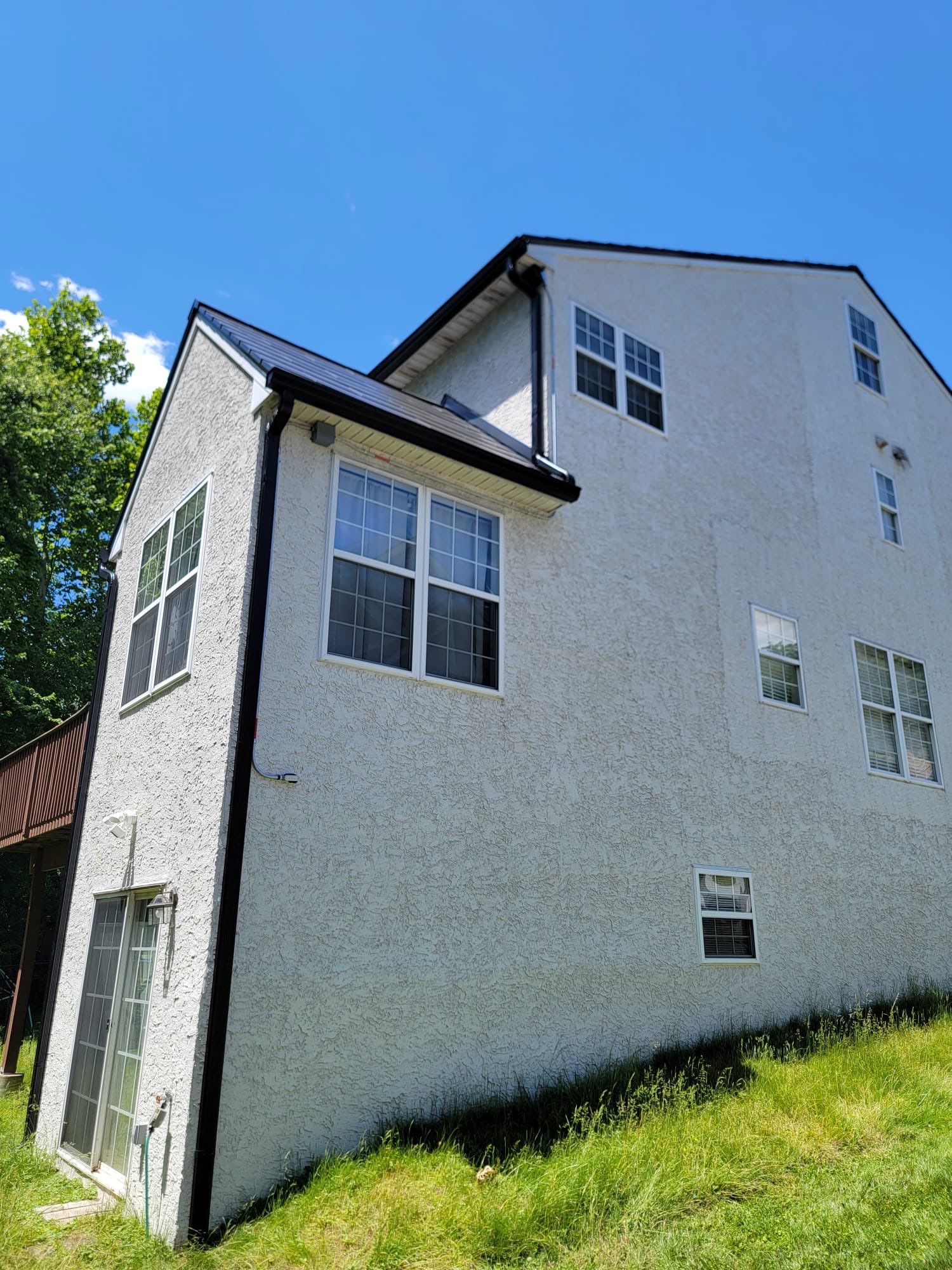Tesla Solar Roof, Powerwall, and Black Gutters by American Home Contractors