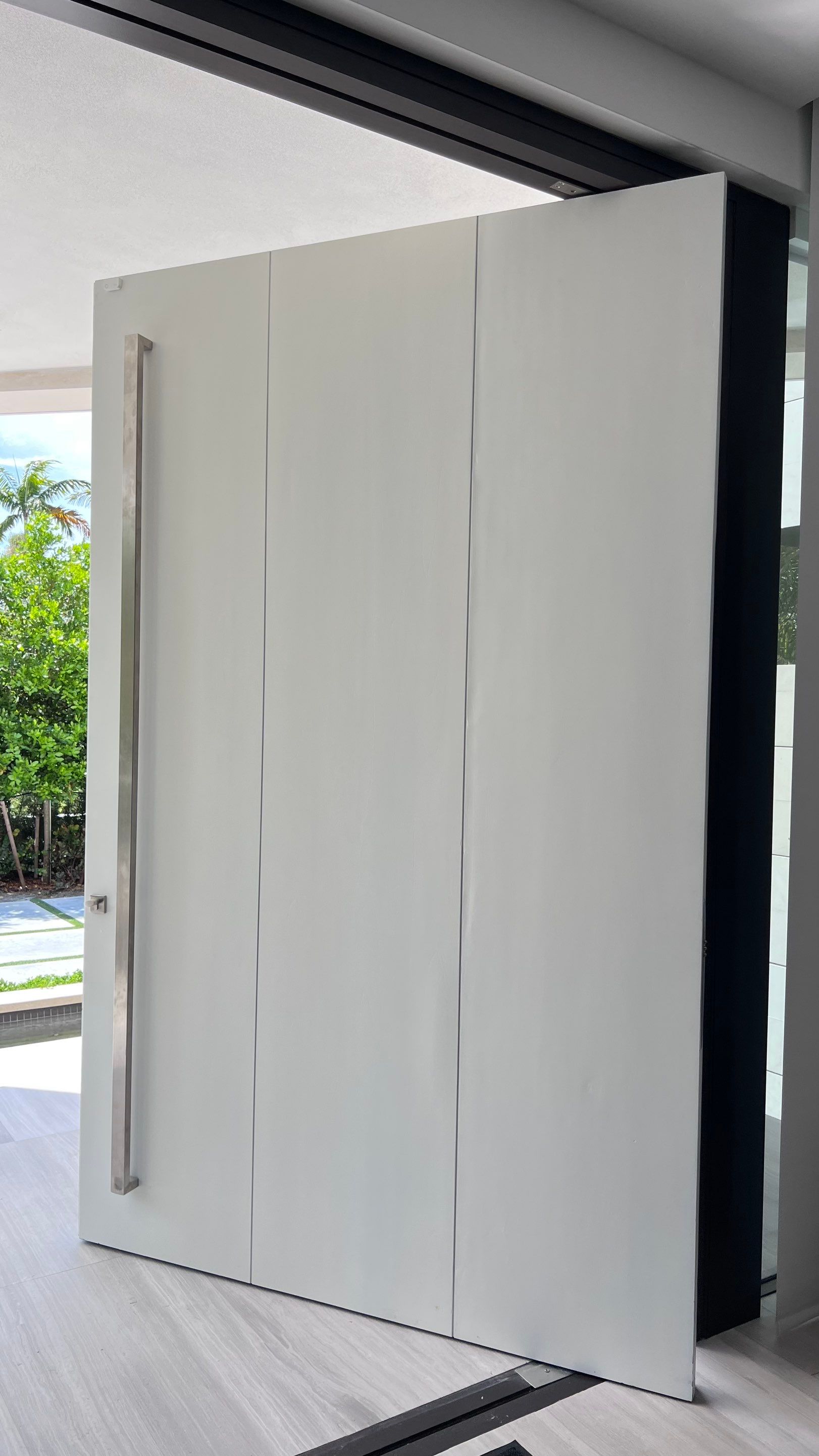 Custom Material Pivot Door installation by Impact Precious Wood Inc.