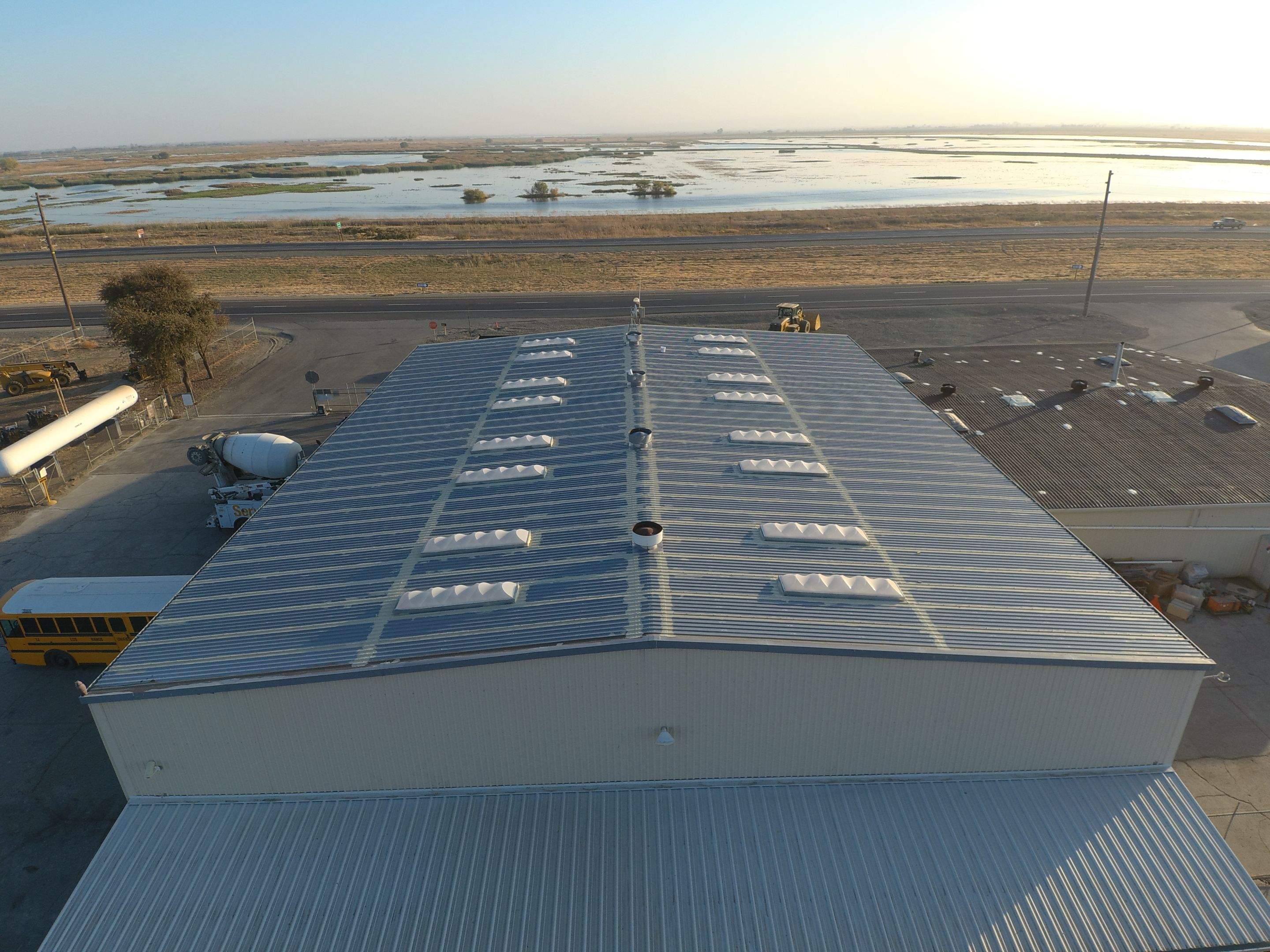 Metal roof restoration on commercial roof using Conklin Benchmark/ PUMA XL acrylic coatings over metal and foam by Straight Edge Roofing Inc