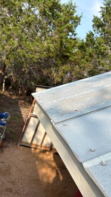 Metal roof edge with trees in background