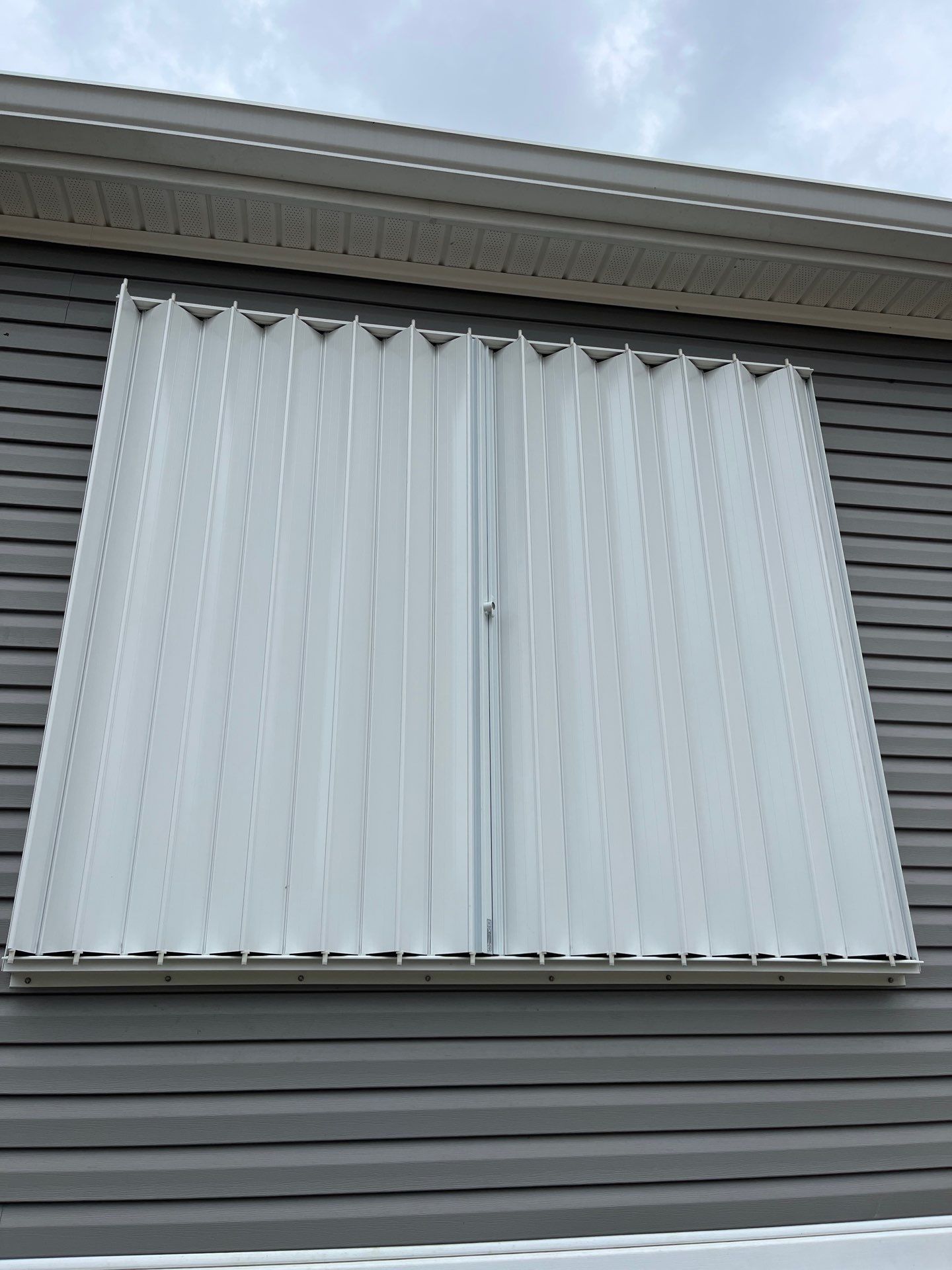 Residential Accordion Hurricane Shutter Installation in Fountain, Florida by Brannan Aluminum Inc.