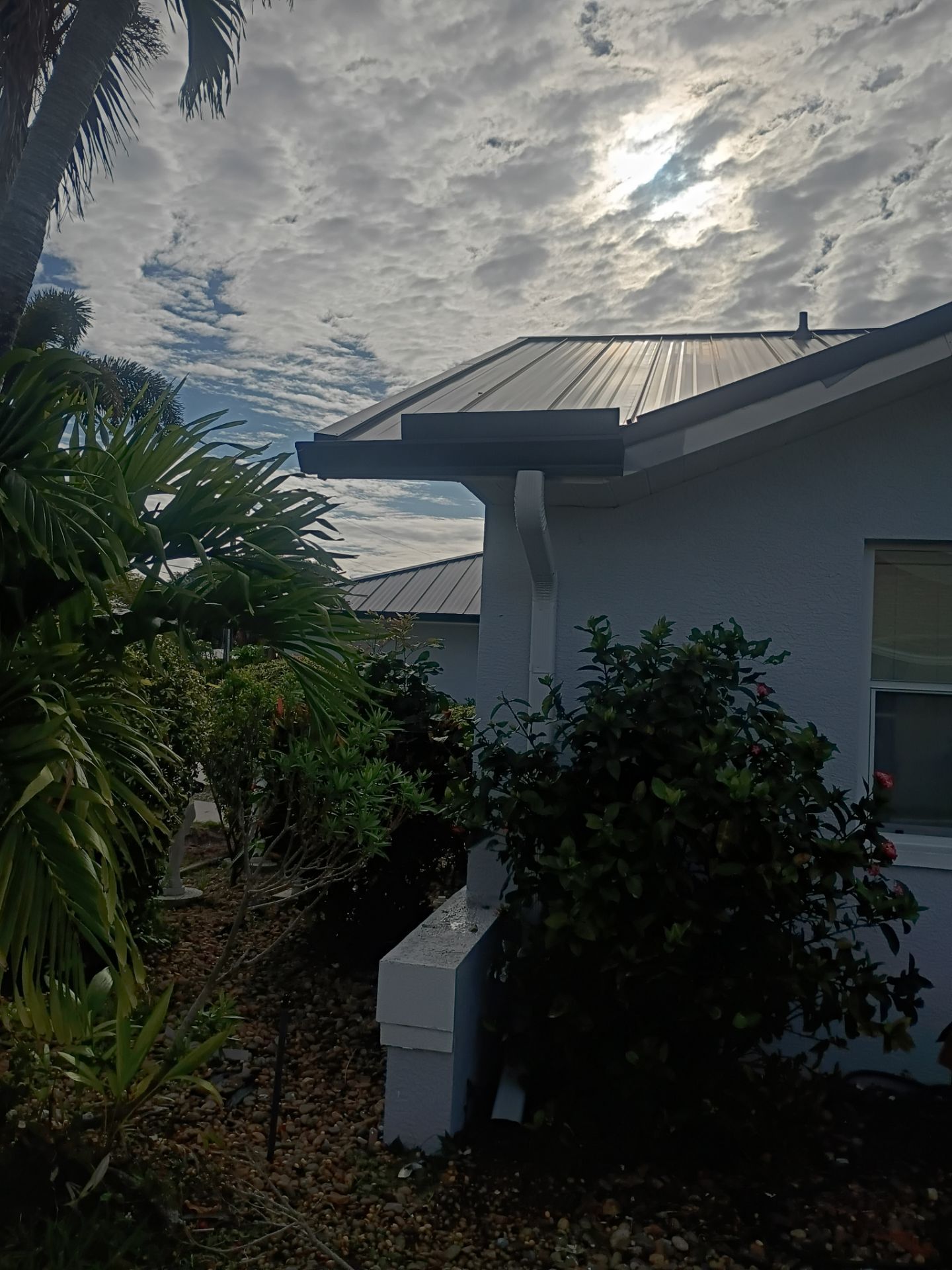 Black Seamless Gutters and White Downspouts in Cape Coral FL by Gutter Professors