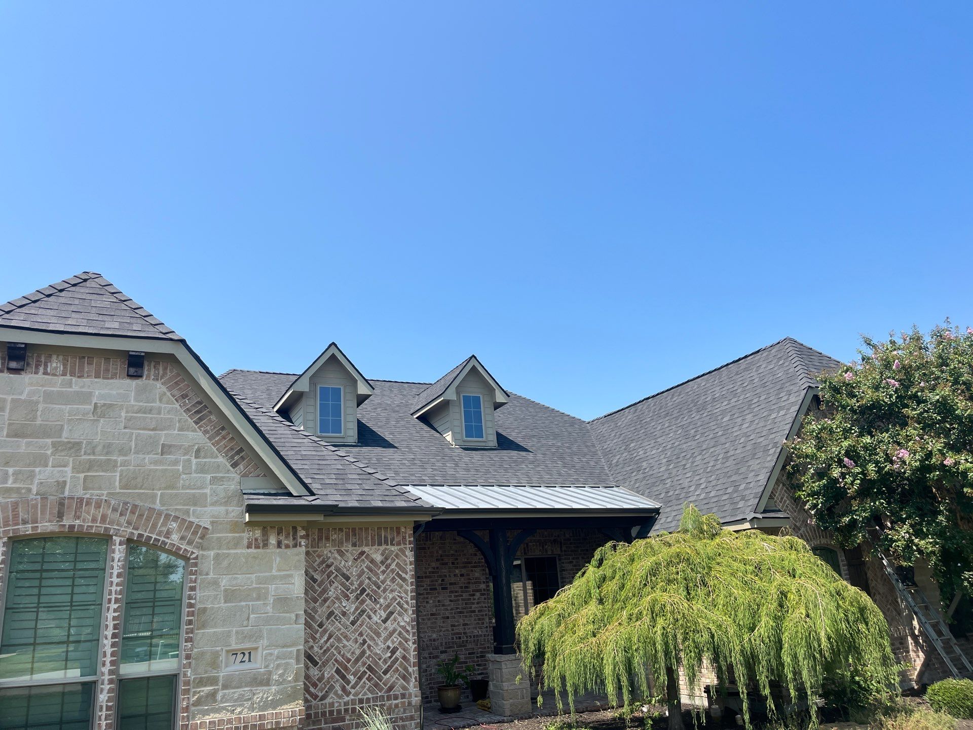 IKO Granite Black-Light Brown with dark brown sections brick house  by Tejas Roofworks + Restoration