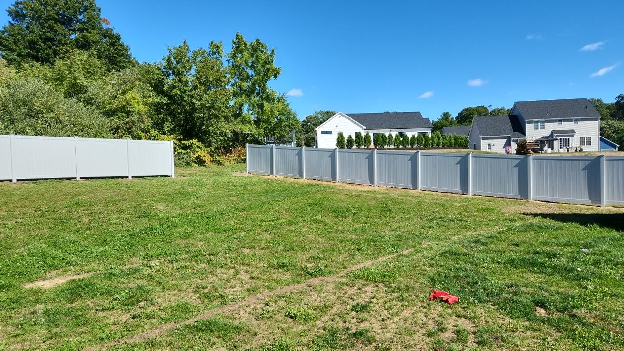 New Vinyl privacy fence with matching gates in Classic Gray by DiGiorgi Roofing and Siding Inc
