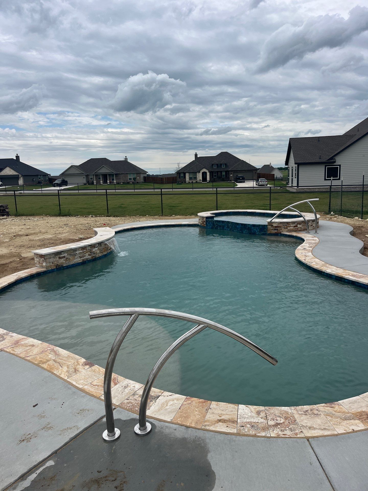Freeform Pool with Raised Spa and Travertine Decking by Pinnacle Pools and Spas - DFW