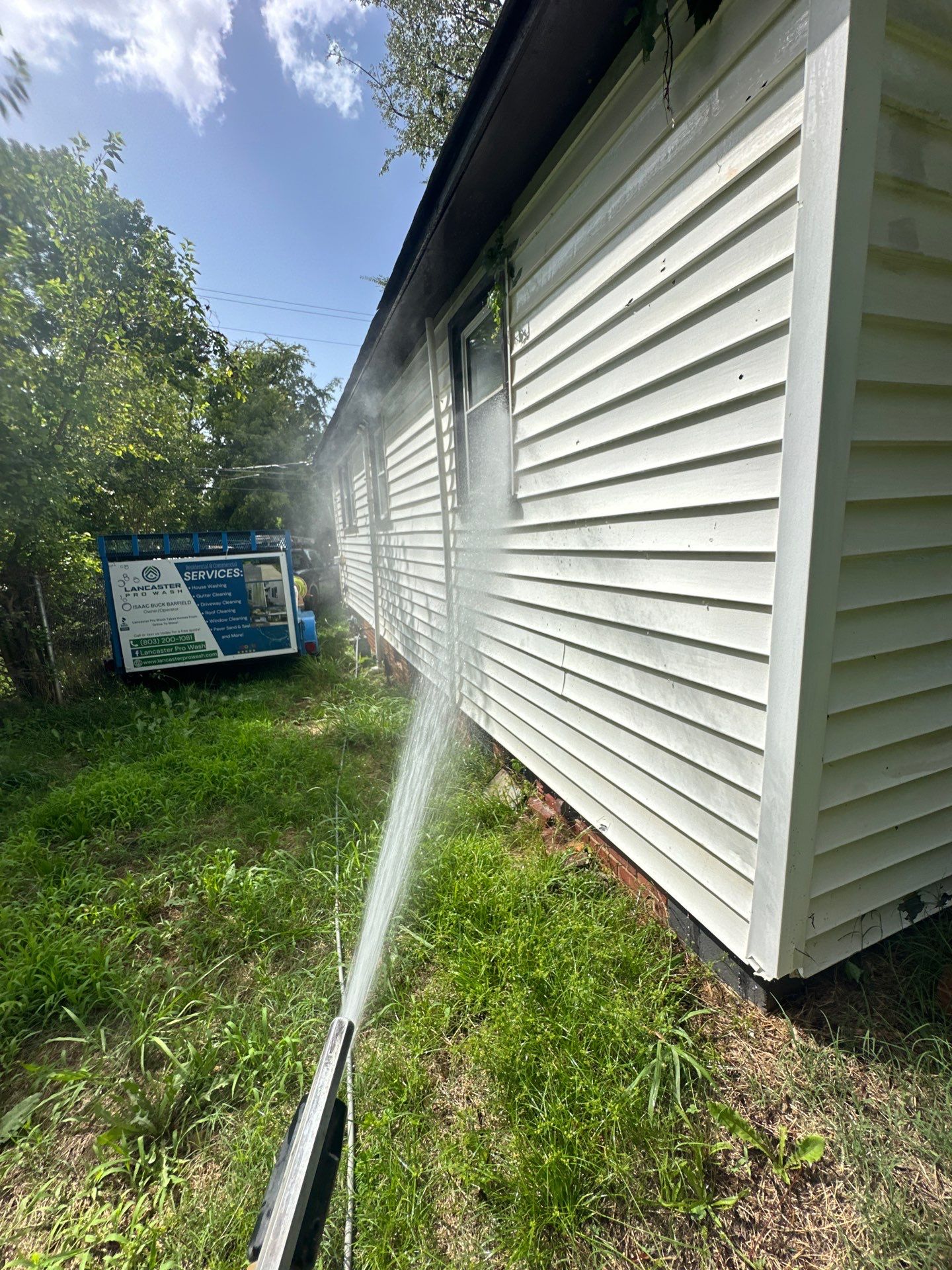 the surface of the house is being cleaned with high pressure water to remove dirt and grime from the siding