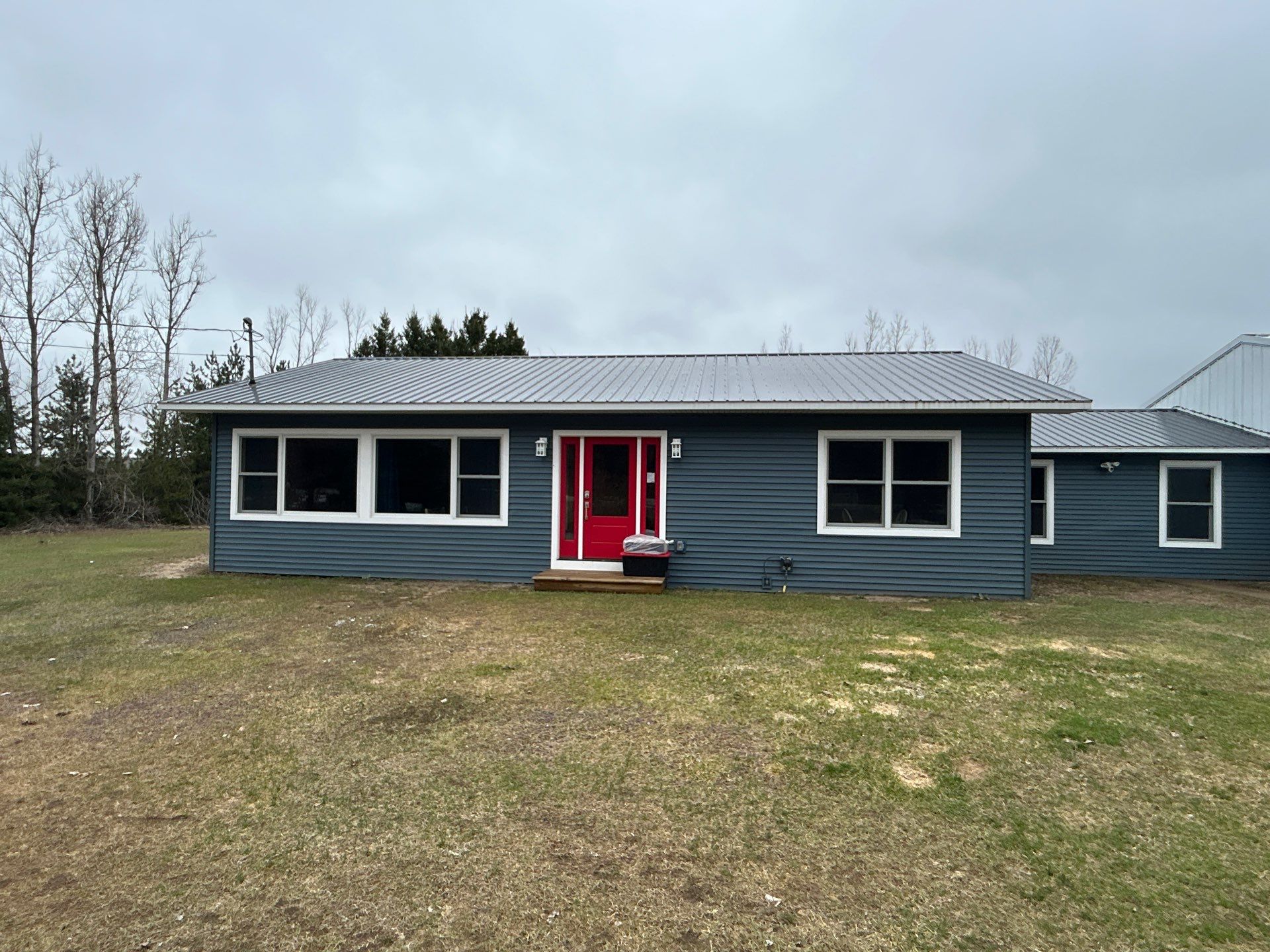 White Gutter and Downspout Installation for Boyne Falls Residential Property by Rainbow Seamless Systems