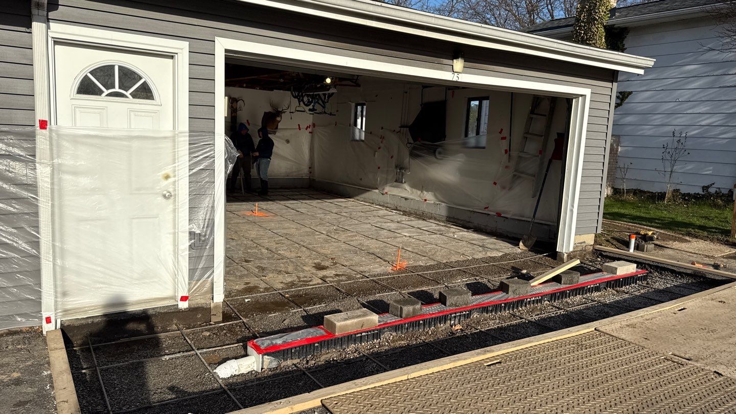 Concrete garage floor replacement with a broom finished apron and drain by NG Masonry & Construction LLC