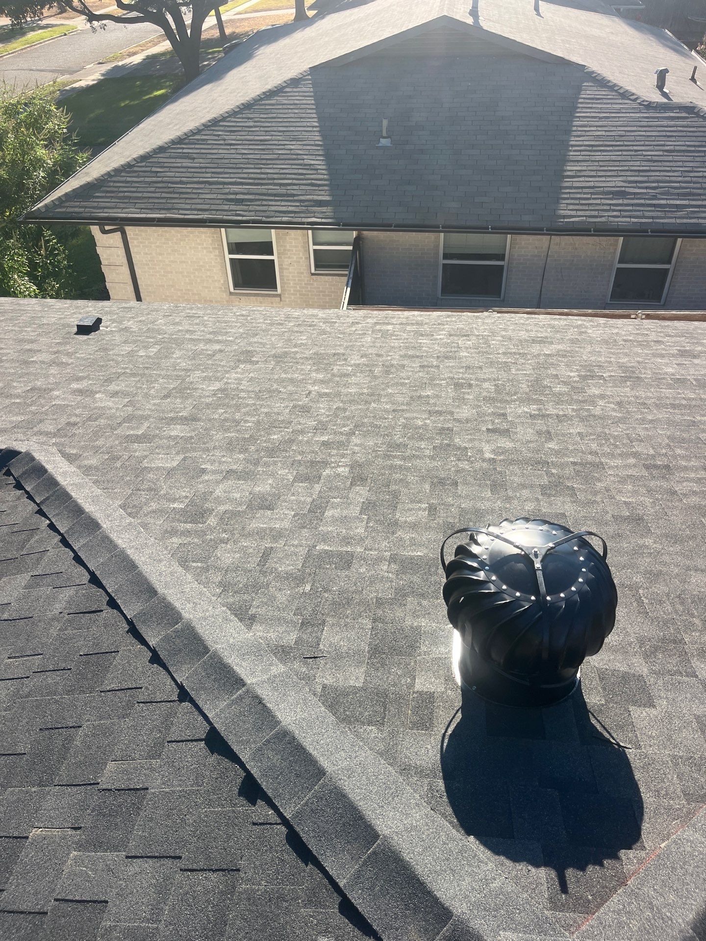 White brick/light gray shutters with IKO Granite Black  by Tejas Roofworks + Restoration