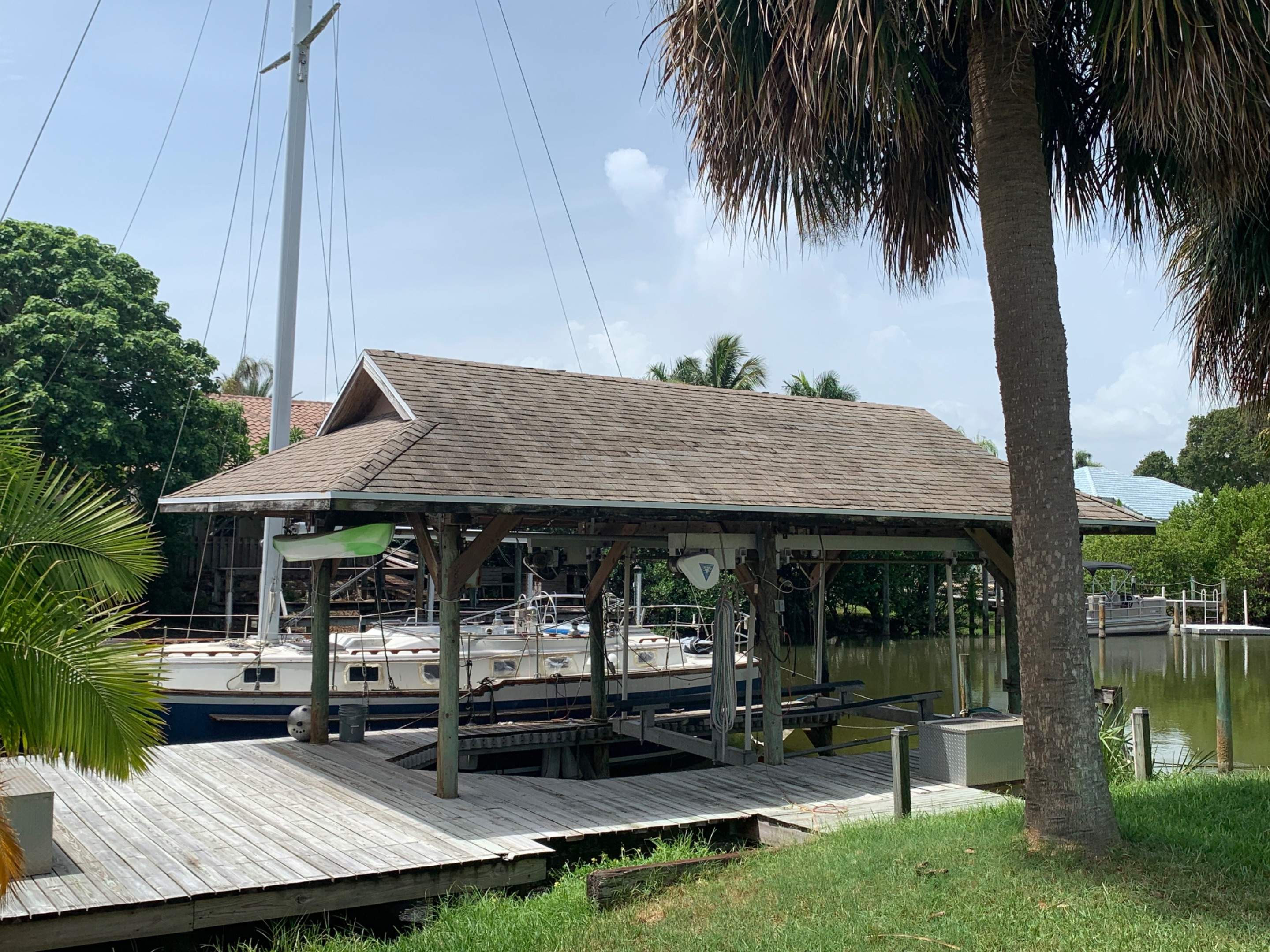 Residential Boat Dock Shingle Roof Installation in Satellite Beach by Florida Roofing and Renovations Inc.