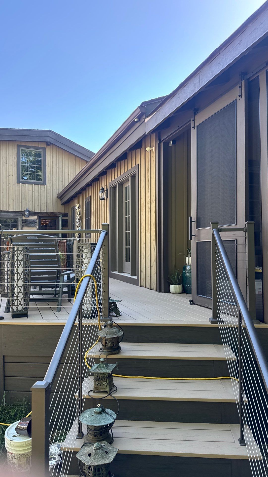 Custom Composite Deck with Stone Fireplace and Modern Cable Railing by Walnut Hollow Decks & Outdoor Living