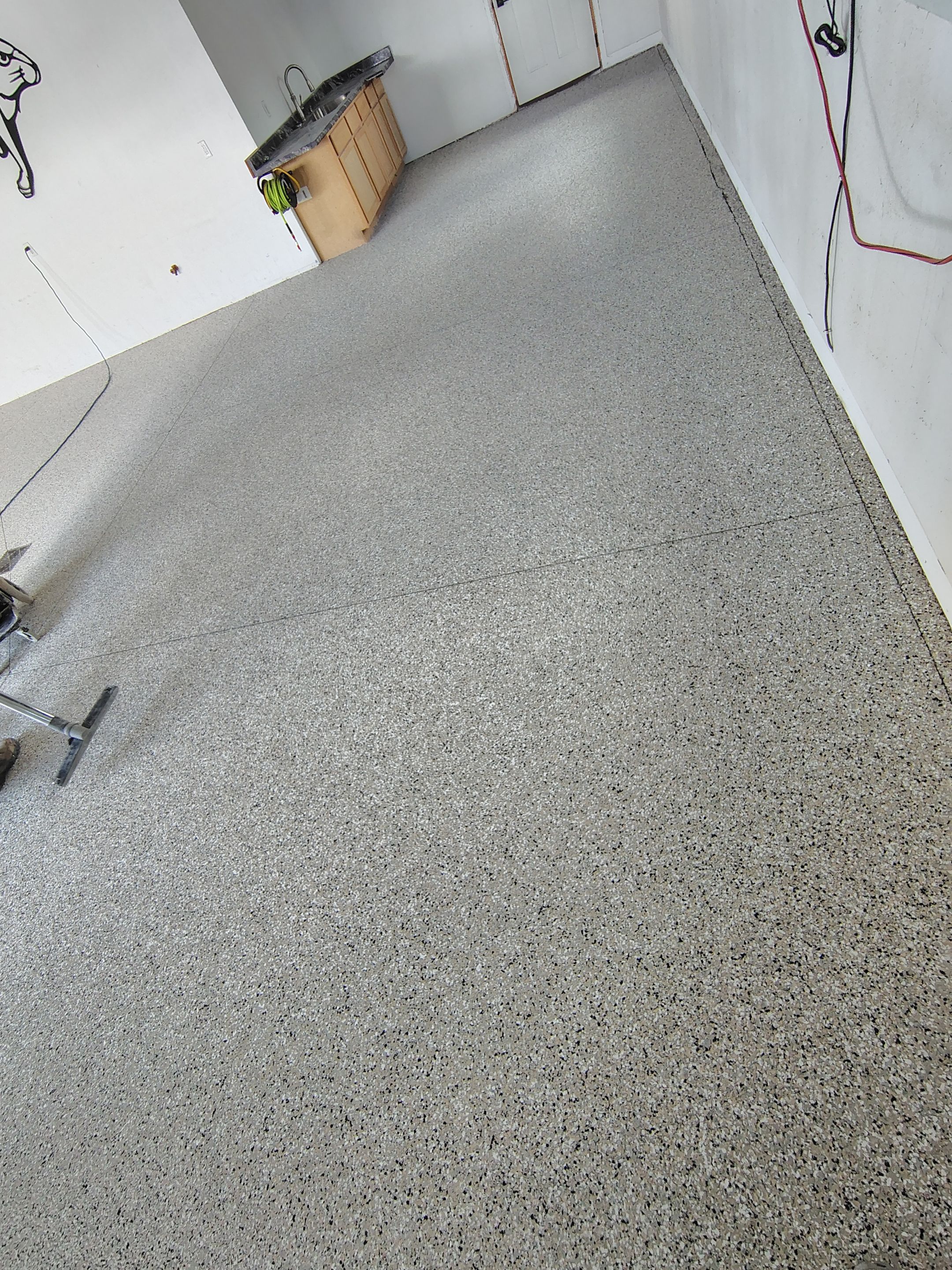 Speckled Polyaspartic Garage Floor Coating Installation in Dell Rapids by Select Painting, Coatings & Garage Cabinets