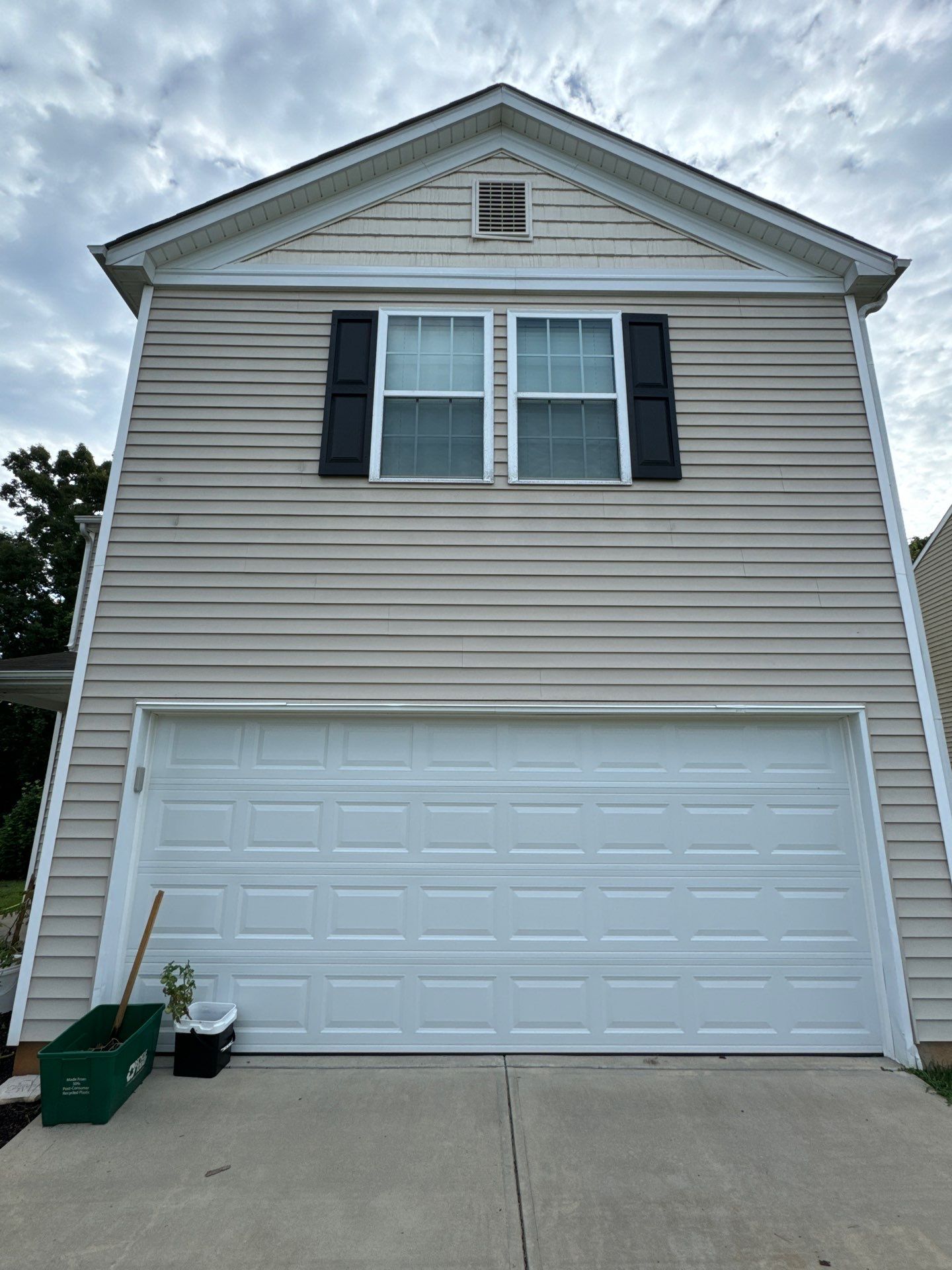 cleaning the house siding and garage door surfaces to remove dirt and grime