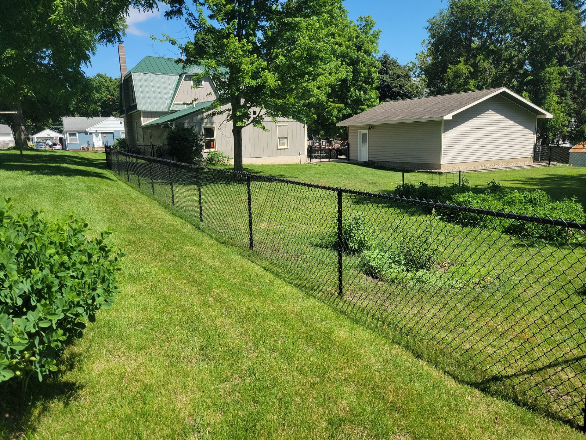 Black Chain Link Perimeter Fence and Driveway Gate in Waverly by Perfect Picket Fence and Stain