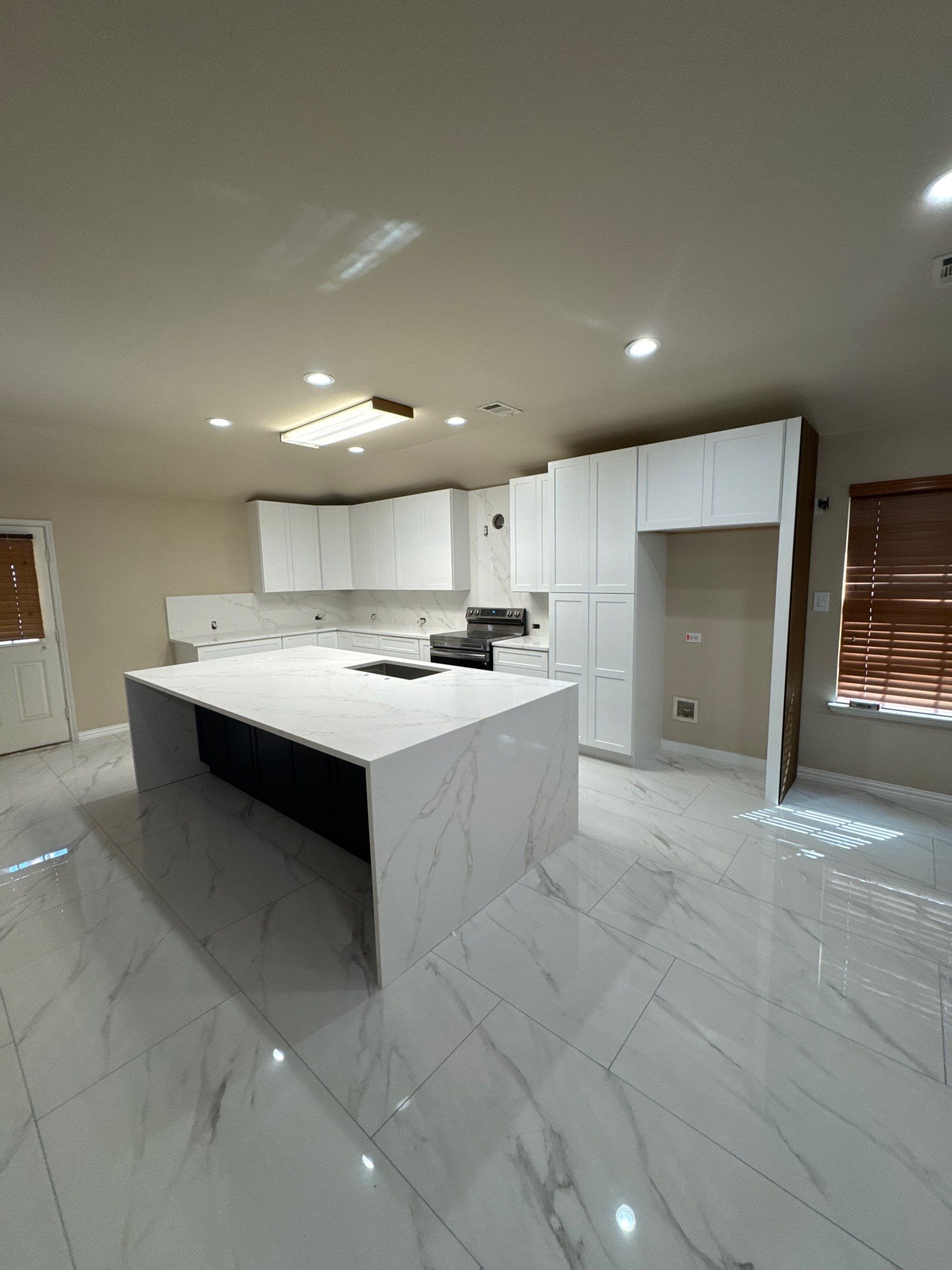 Luxury Focal Point: Full Kitchen Remodel with Double Waterfall Island by Tibi Soli LLC