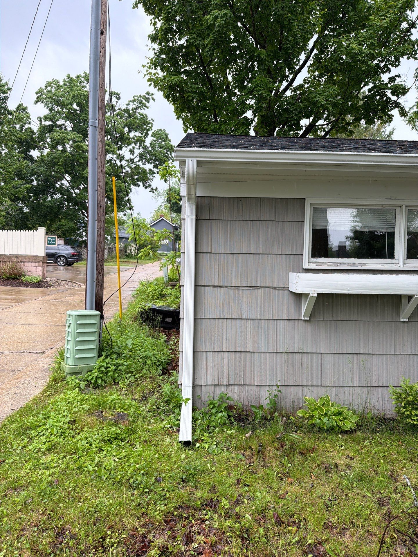 White Gutter and Downspout System Installation in Petoskey by Rainbow Seamless Systems