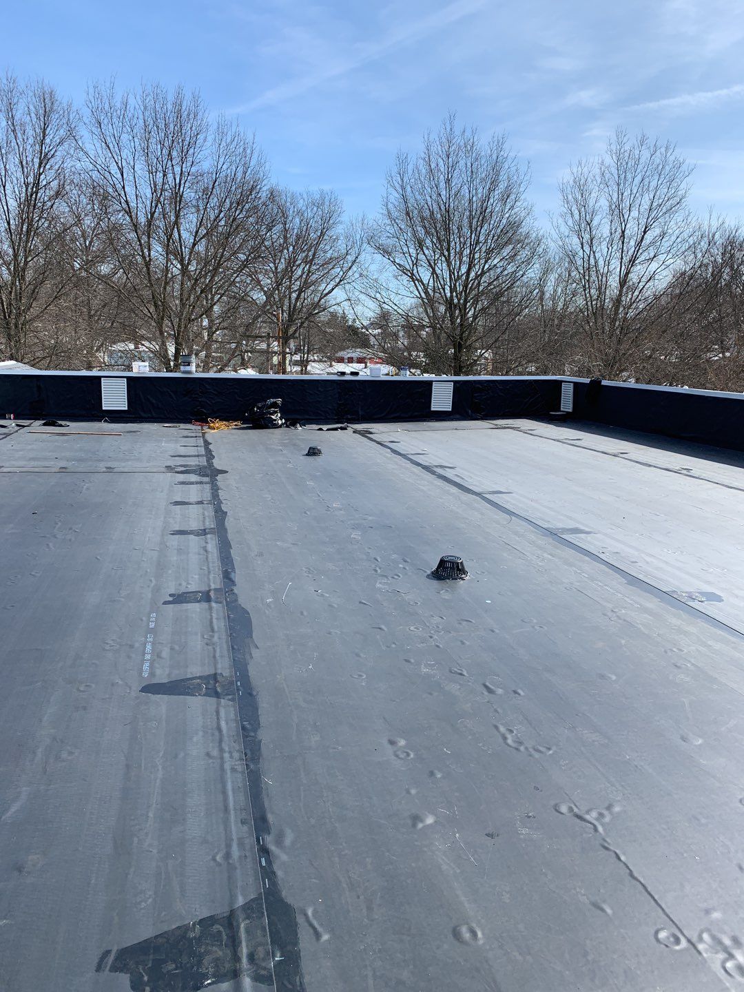 Commercial Roofing Installation using EPDM with white gutters by A Plus Exterior