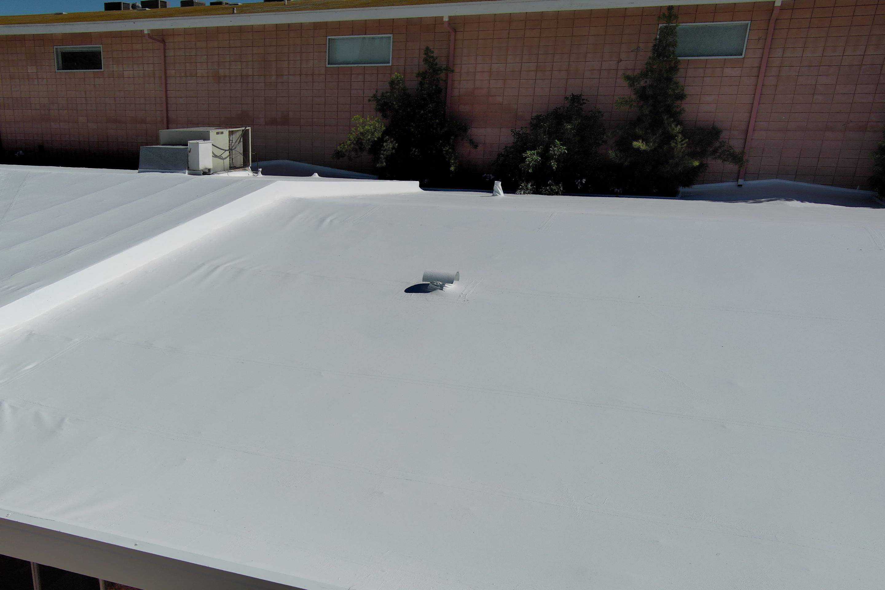 Single-ply restoration system using Benchmark/PUMA XL coatings over TPO single-ply roofing by Straight Edge Roofing Inc