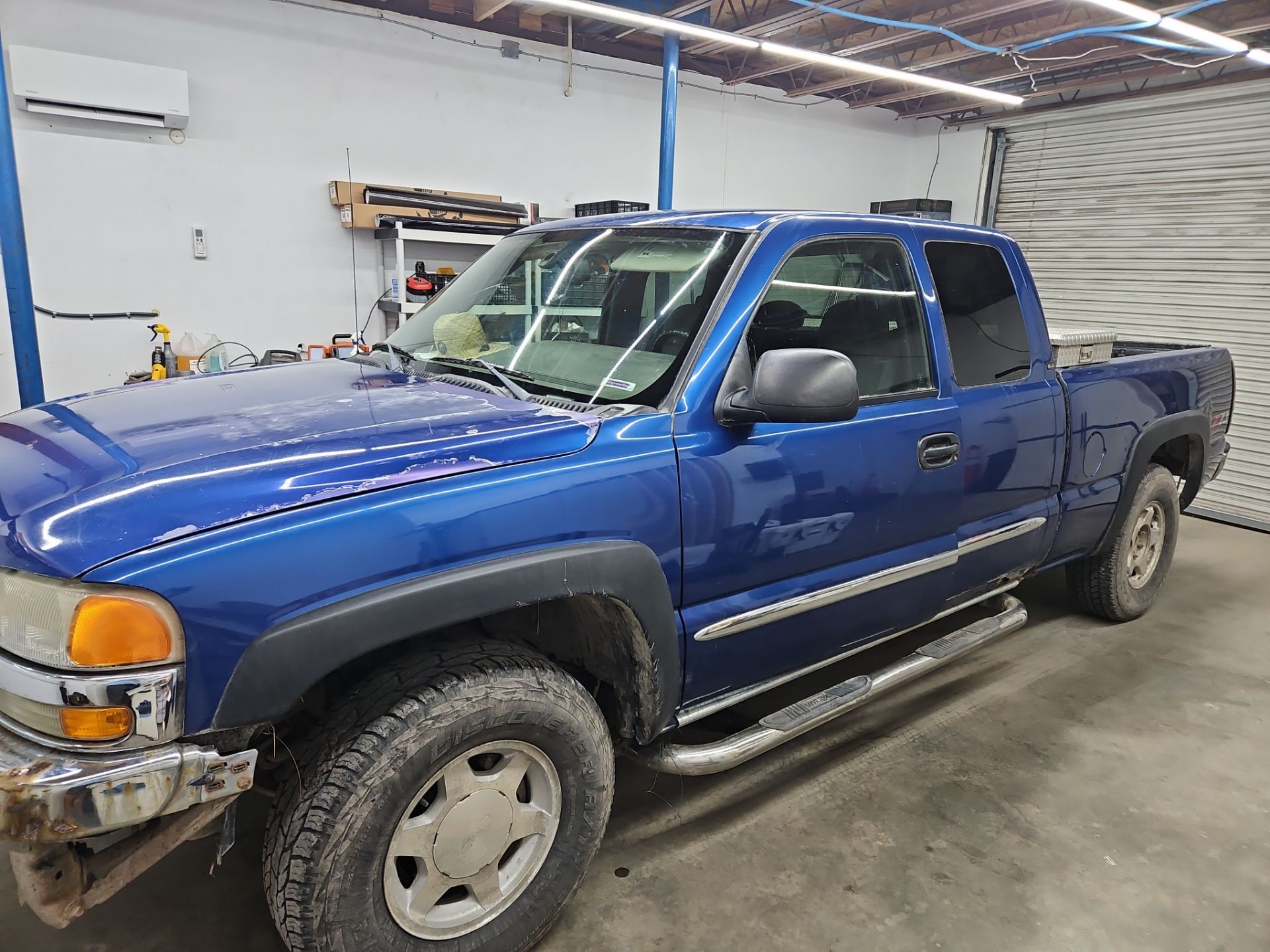 the service being done is window tinting on a blue pickup truck the tint is applied to improve privacy and reduce heat inside the vehicle the windows are being carefully cleaned and prepped before the film is installed the truck has visible wear but the tint will enhance its appearance and functionality the team at t's window tinting is ensuring a professional finish to protect the interior and increase comfort for the driver and passengers