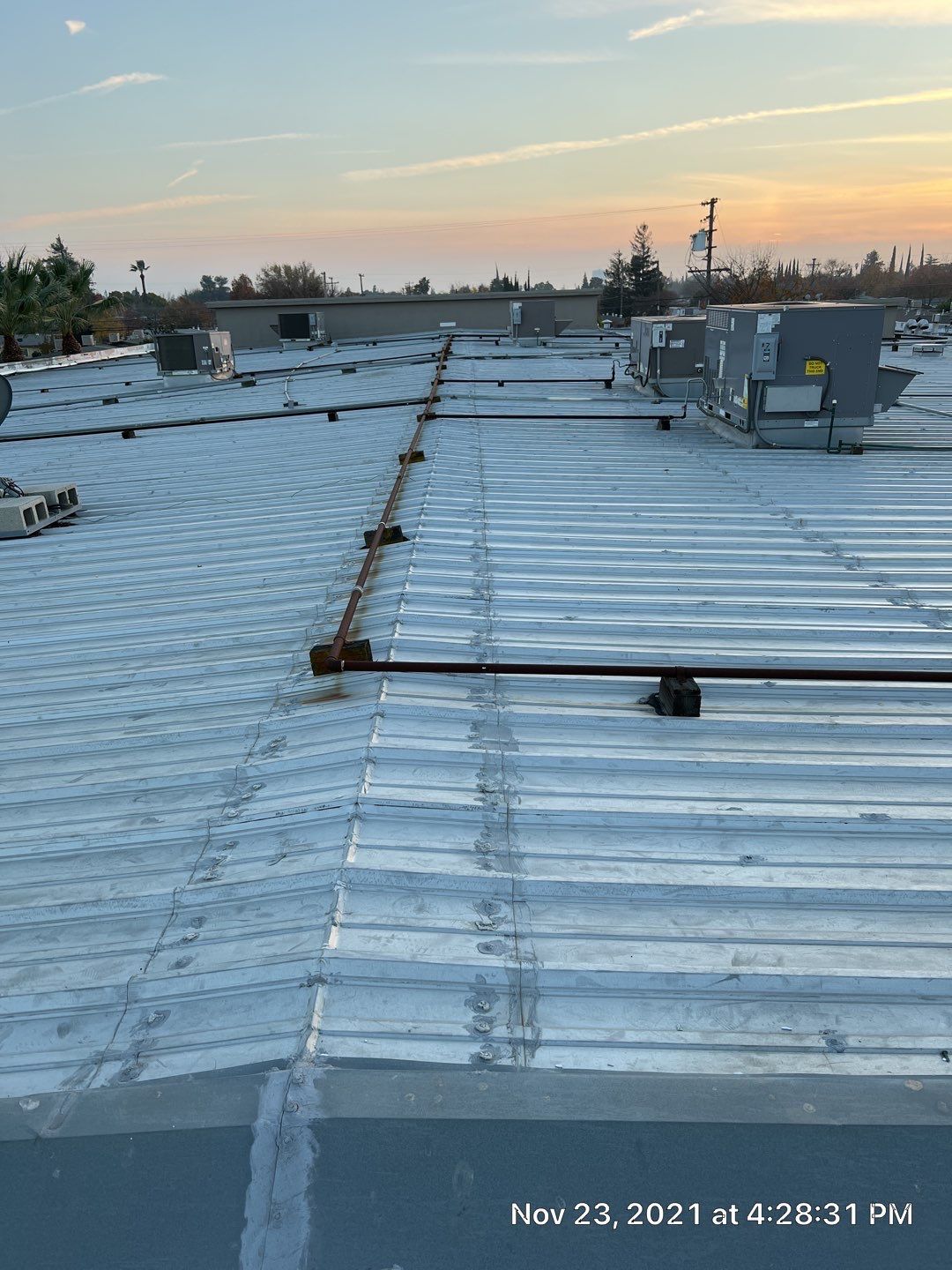 Metal roof restoration on commercial roof using Conklin Benchmark/ PUMA XL acrylic coatings over metal and foam by Straight Edge Roofing Inc