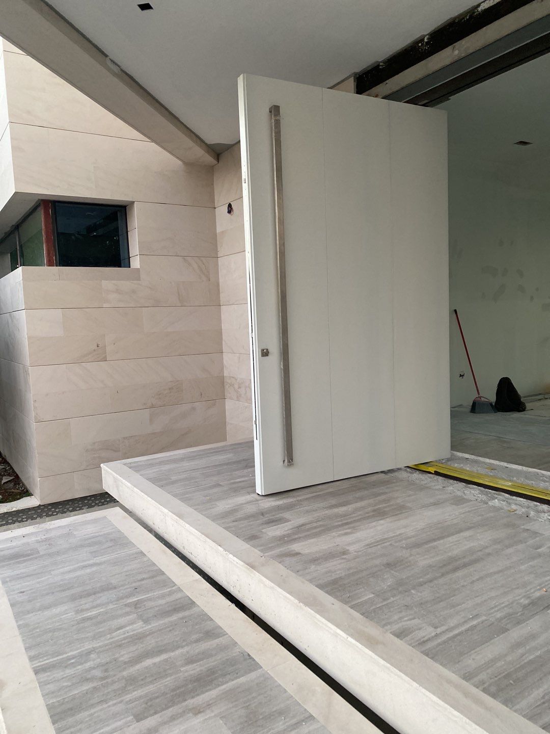 Custom Material Pivot Door installation by Impact Precious Wood Inc.