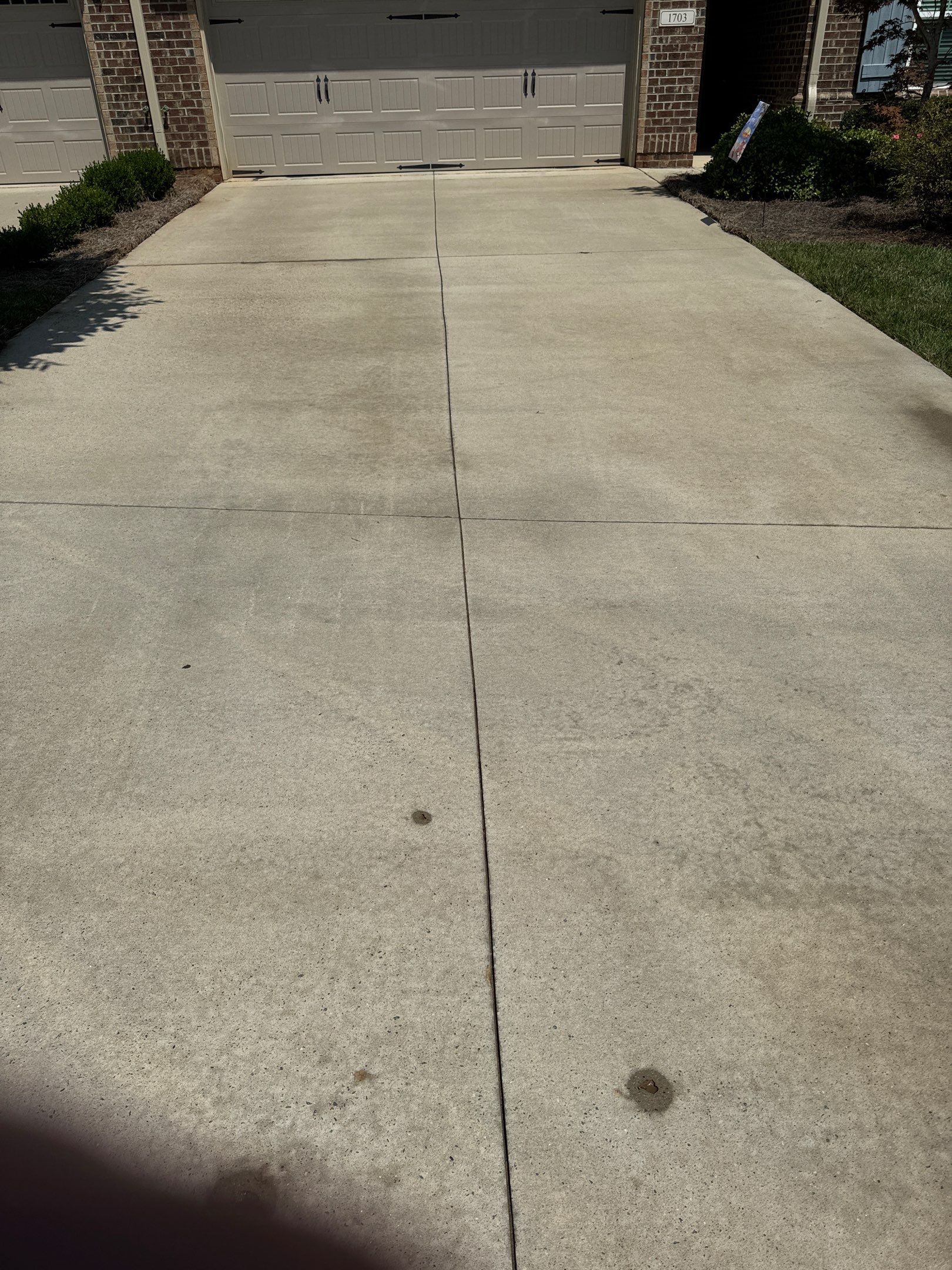 pressure washing of a concrete driveway to remove dirt and stains restoring its clean appearance and enhancing curb appeal