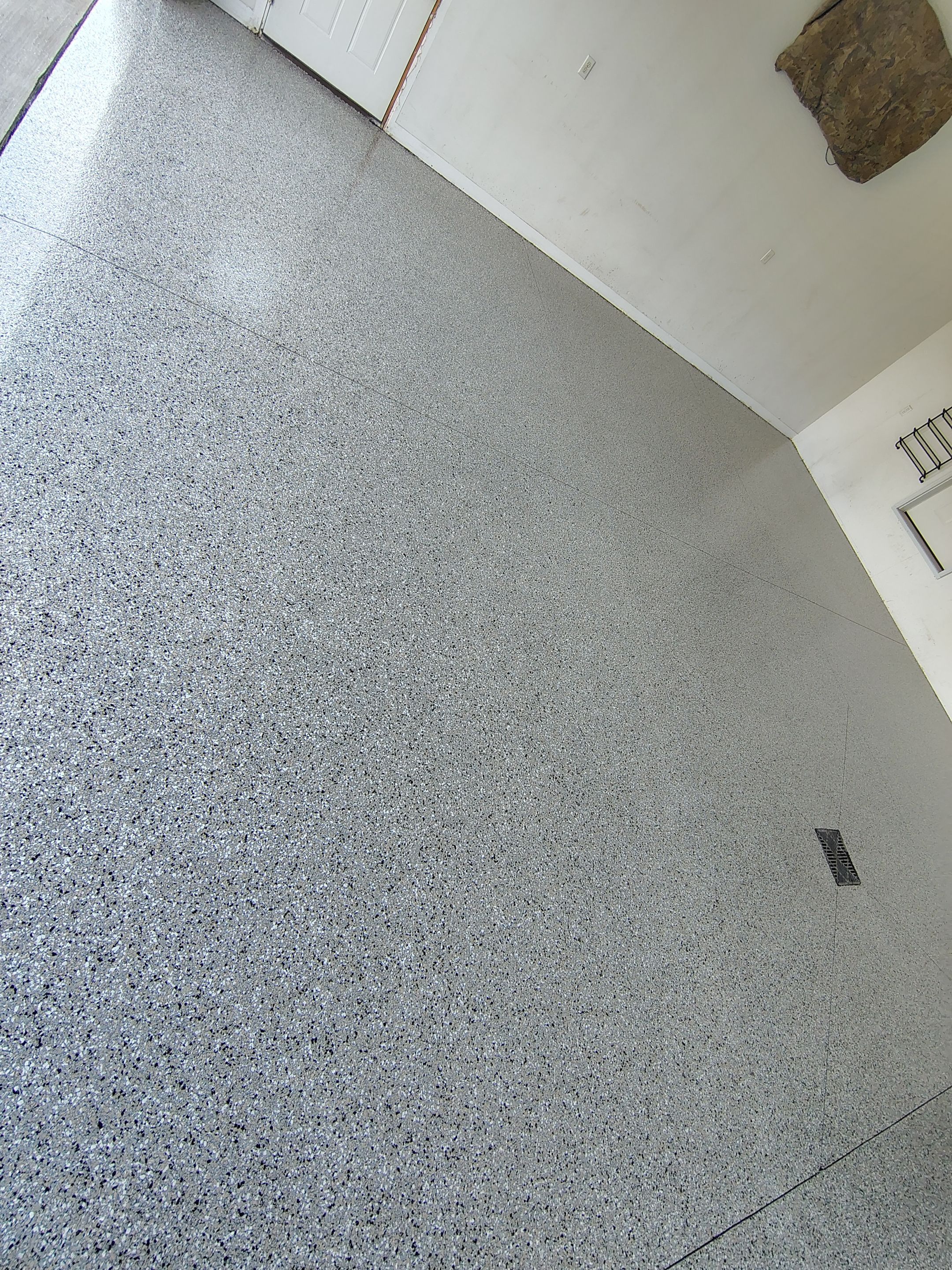 Speckled Polyaspartic Garage Floor Coating Installation in Dell Rapids by Select Painting, Coatings & Garage Cabinets