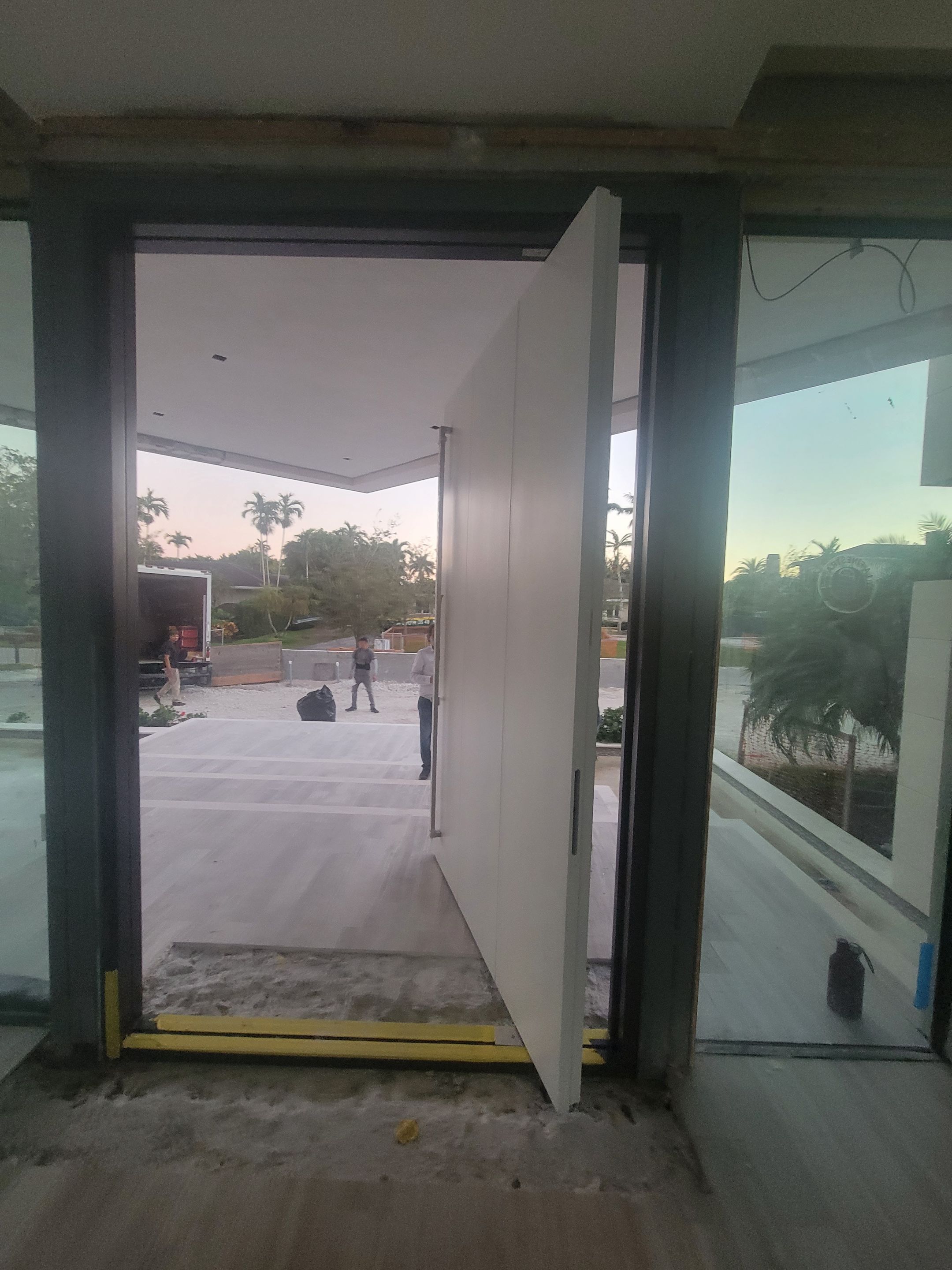 Custom Material Pivot Door installation by Impact Precious Wood Inc.
