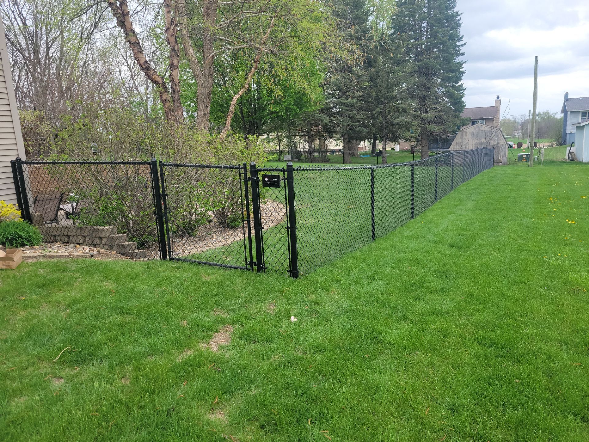 Residential Black Vinyl-Coated Chain Link Perimeter Fence in Garwin by Perfect Picket Fence and Stain