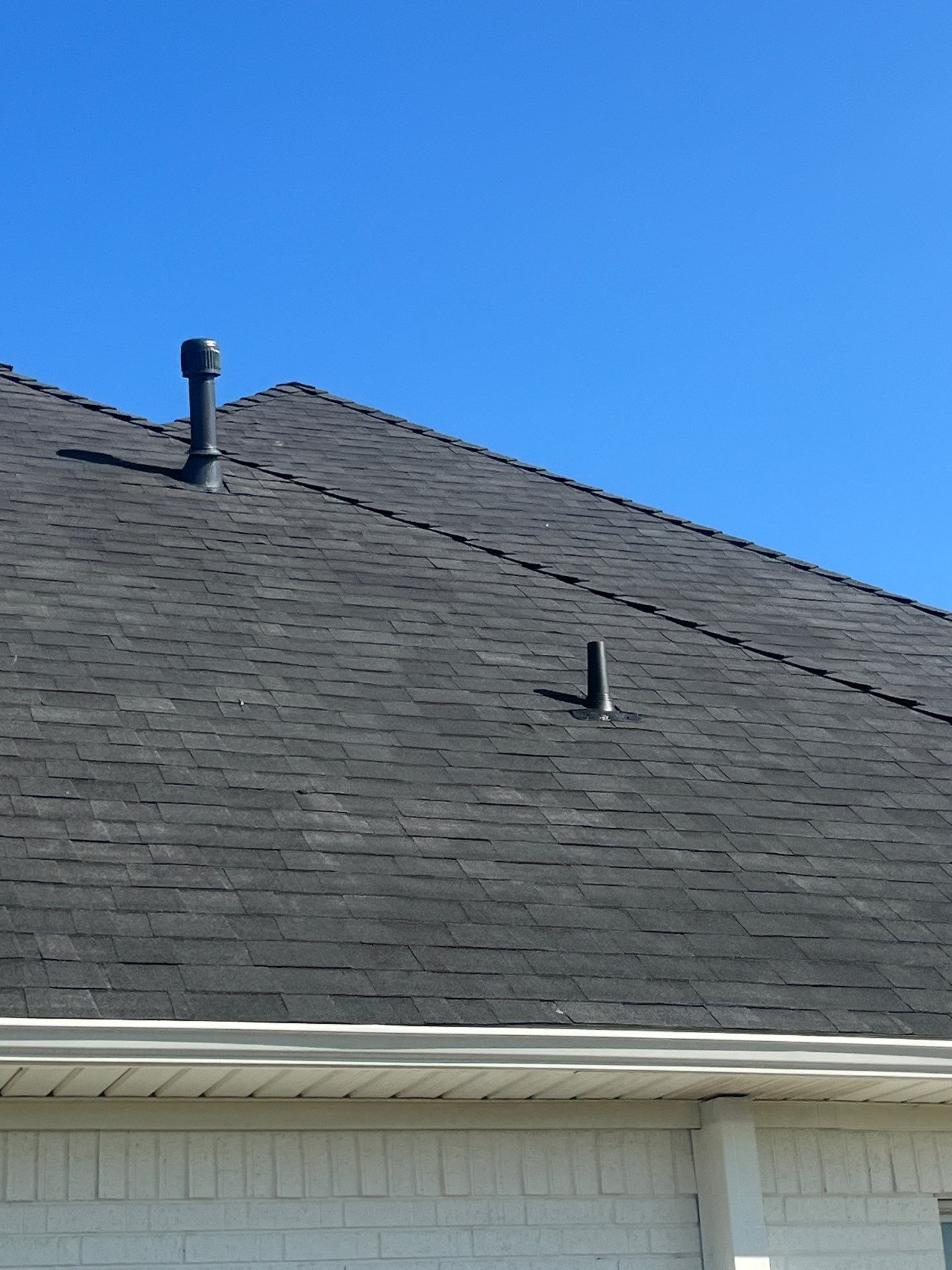 White brick with Malarkey Brilliant Black by Tejas Roofworks + Restoration