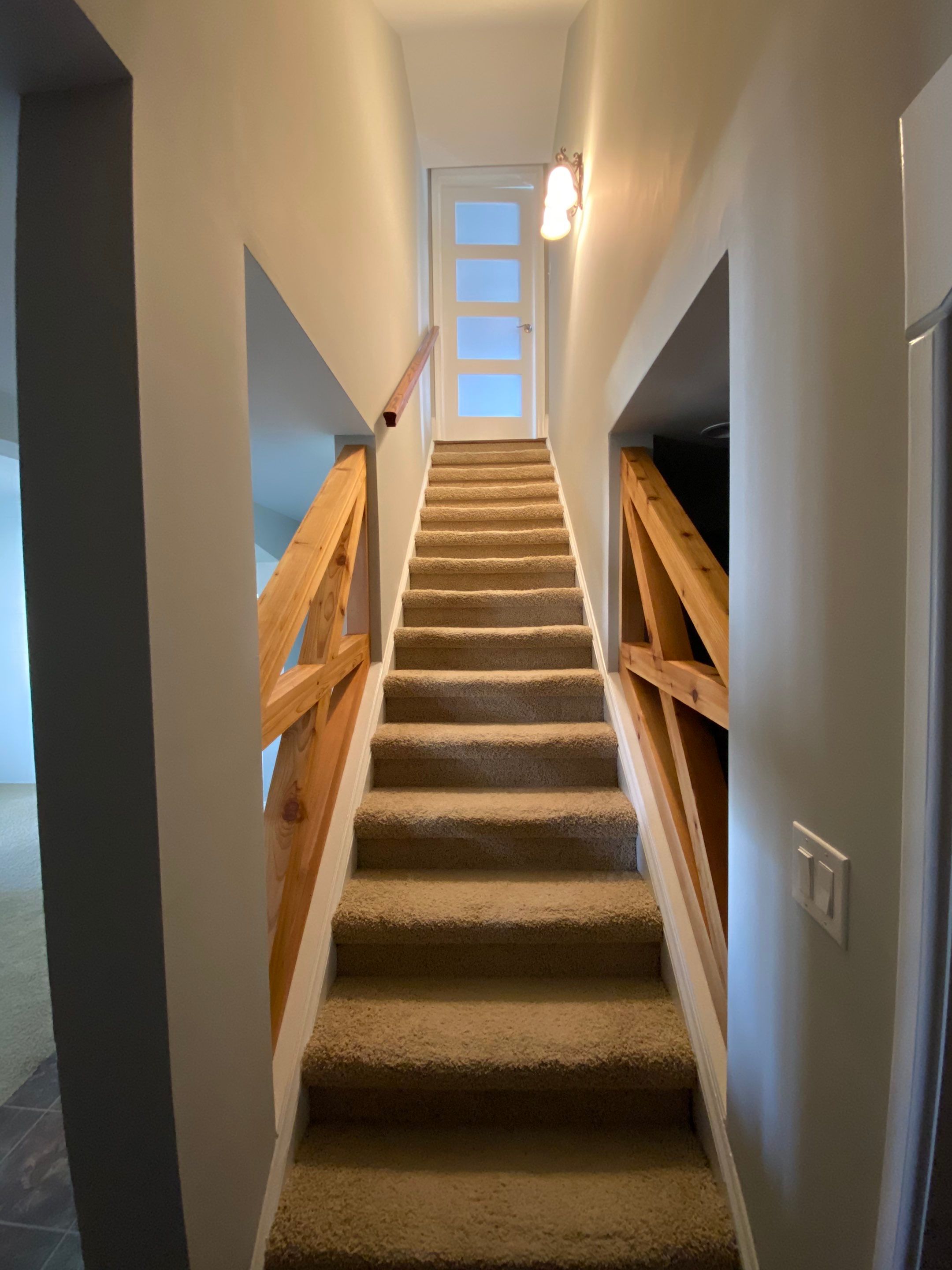 Finished Basement Renovation with Custom Shiplap and Modernized Wood Railings by Swift Home Renovations 