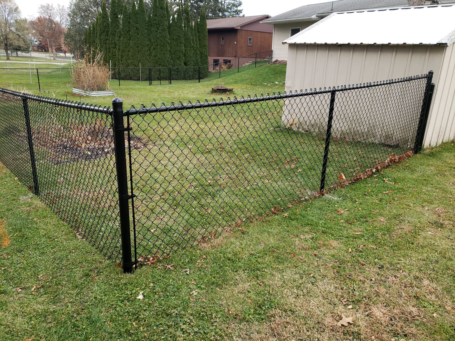 Residential Black Vinyl-Coated Chain Link Fence in Grundy Center by Perfect Picket Fence and Stain
