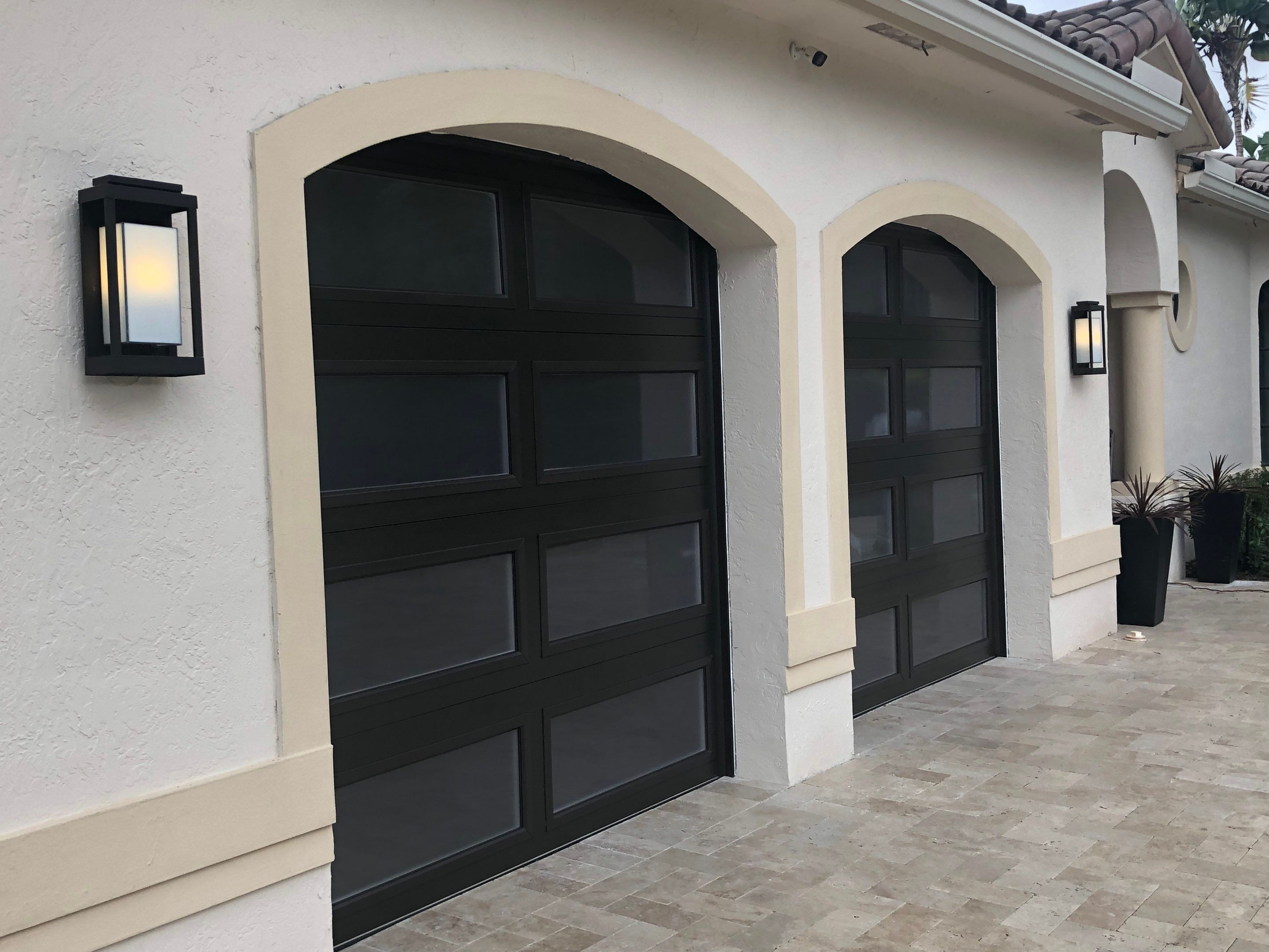 Modern Bronze Garage Door Installation With Frosted Glass in Boca Raton by The Door Doctor of South Florida, Inc.