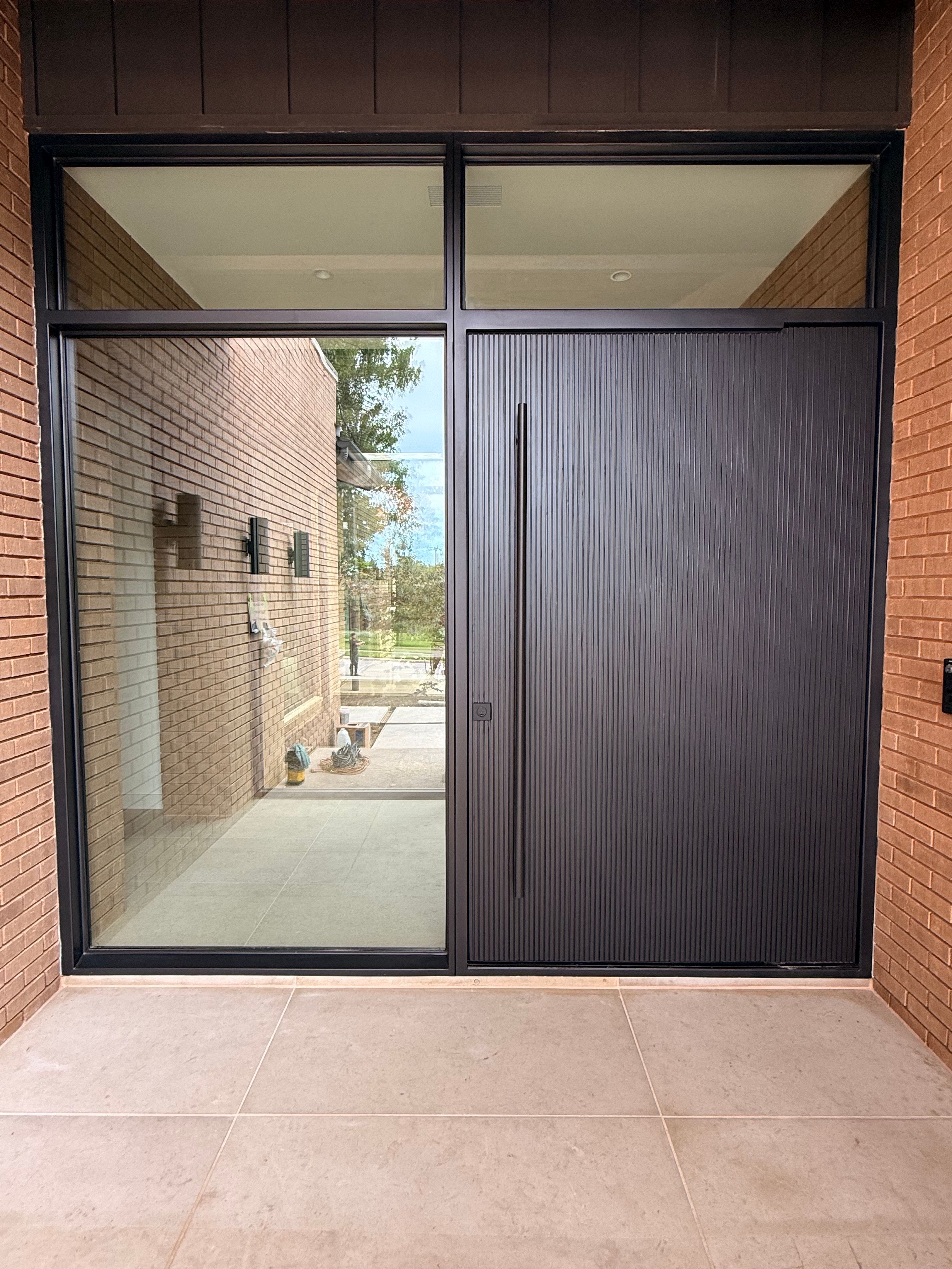 Custom Steel Oporto Pivot Door Installation for Dallas New Construction by Solara Custom Living