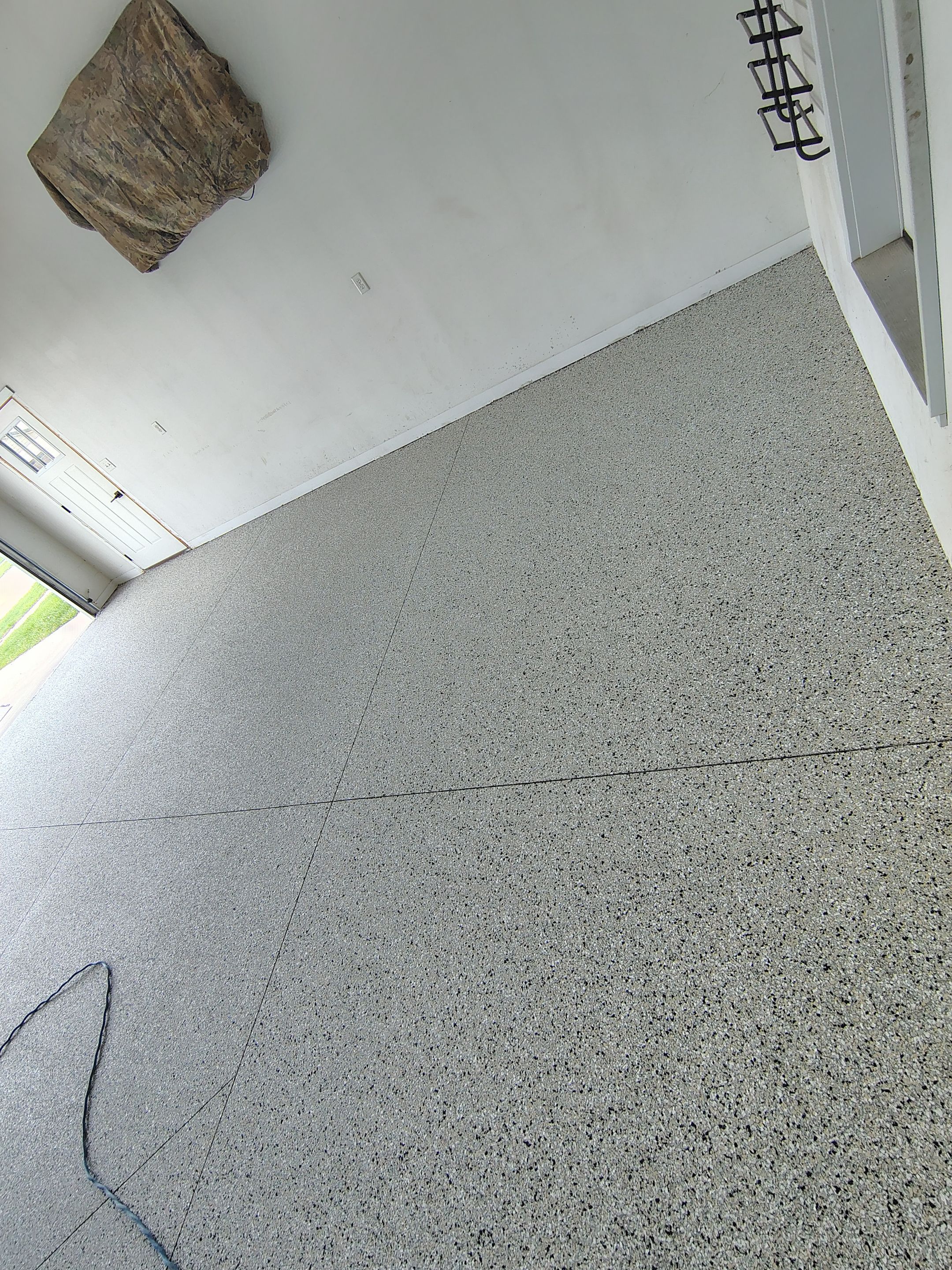 Speckled Polyaspartic Garage Floor Coating Installation in Dell Rapids by Select Painting, Coatings & Garage Cabinets
