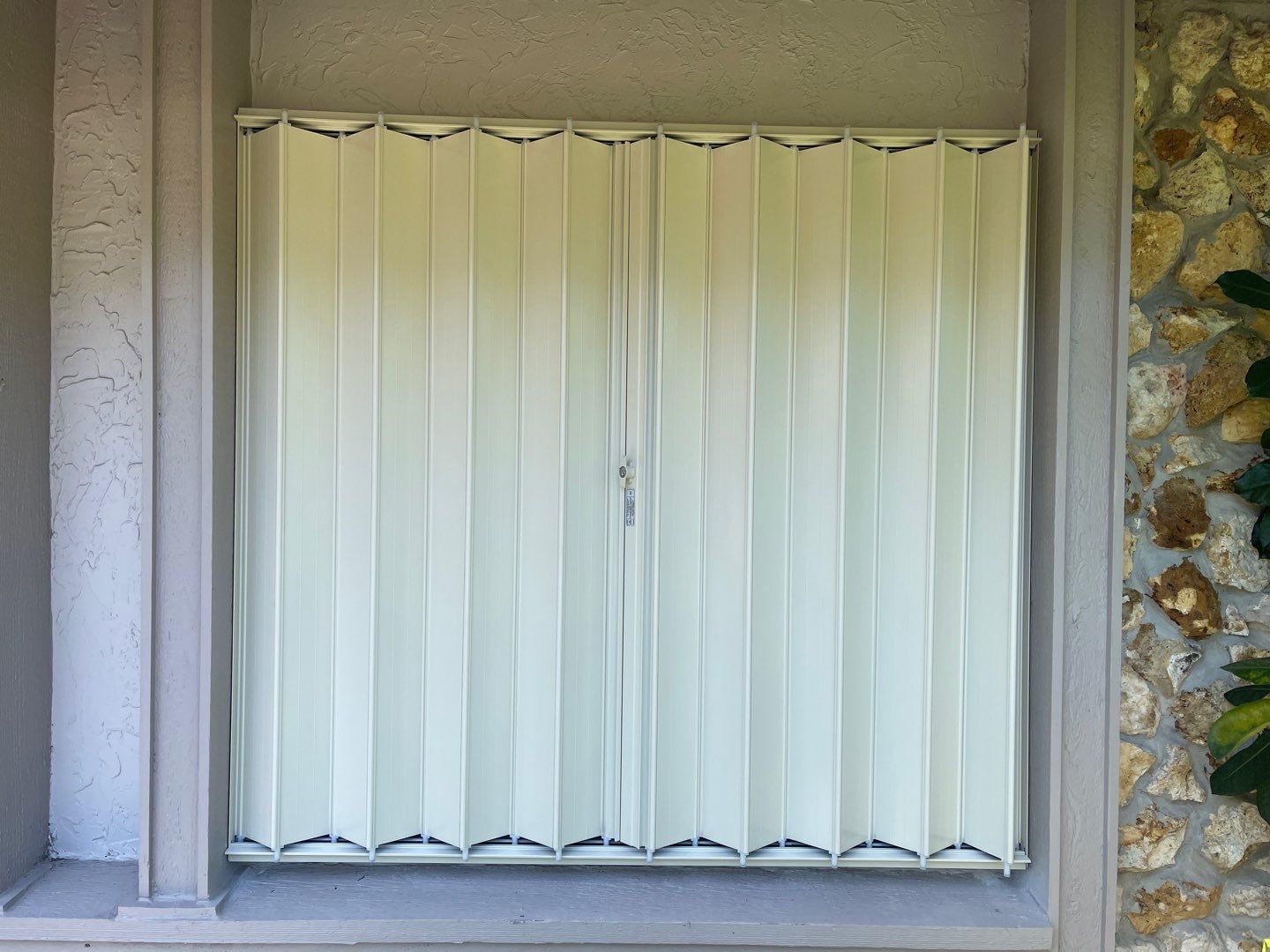 Ivory accordion shutters by Smart Guard Shutters