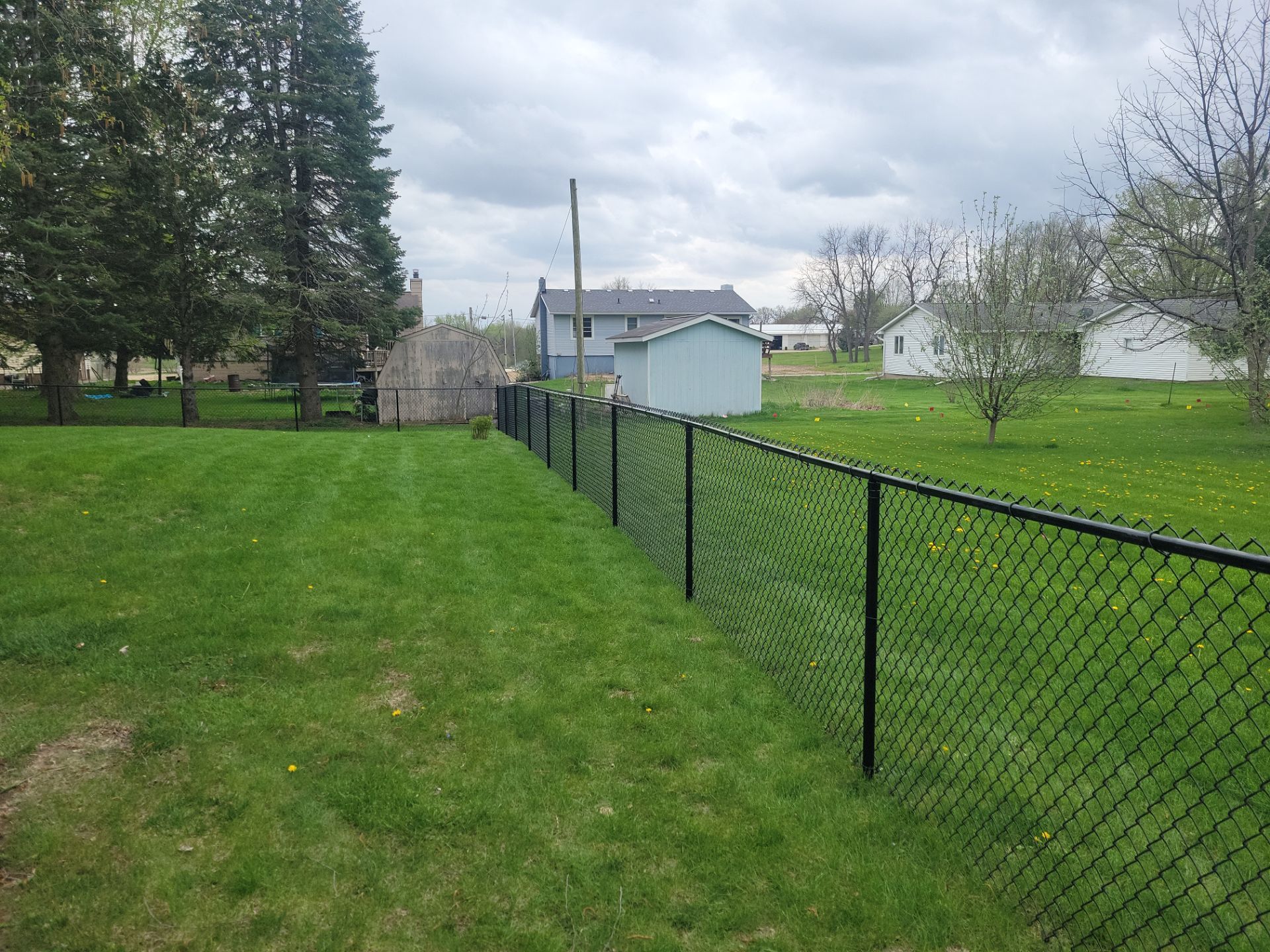 Residential Black Vinyl-Coated Chain Link Perimeter Fence in Garwin by Perfect Picket Fence and Stain