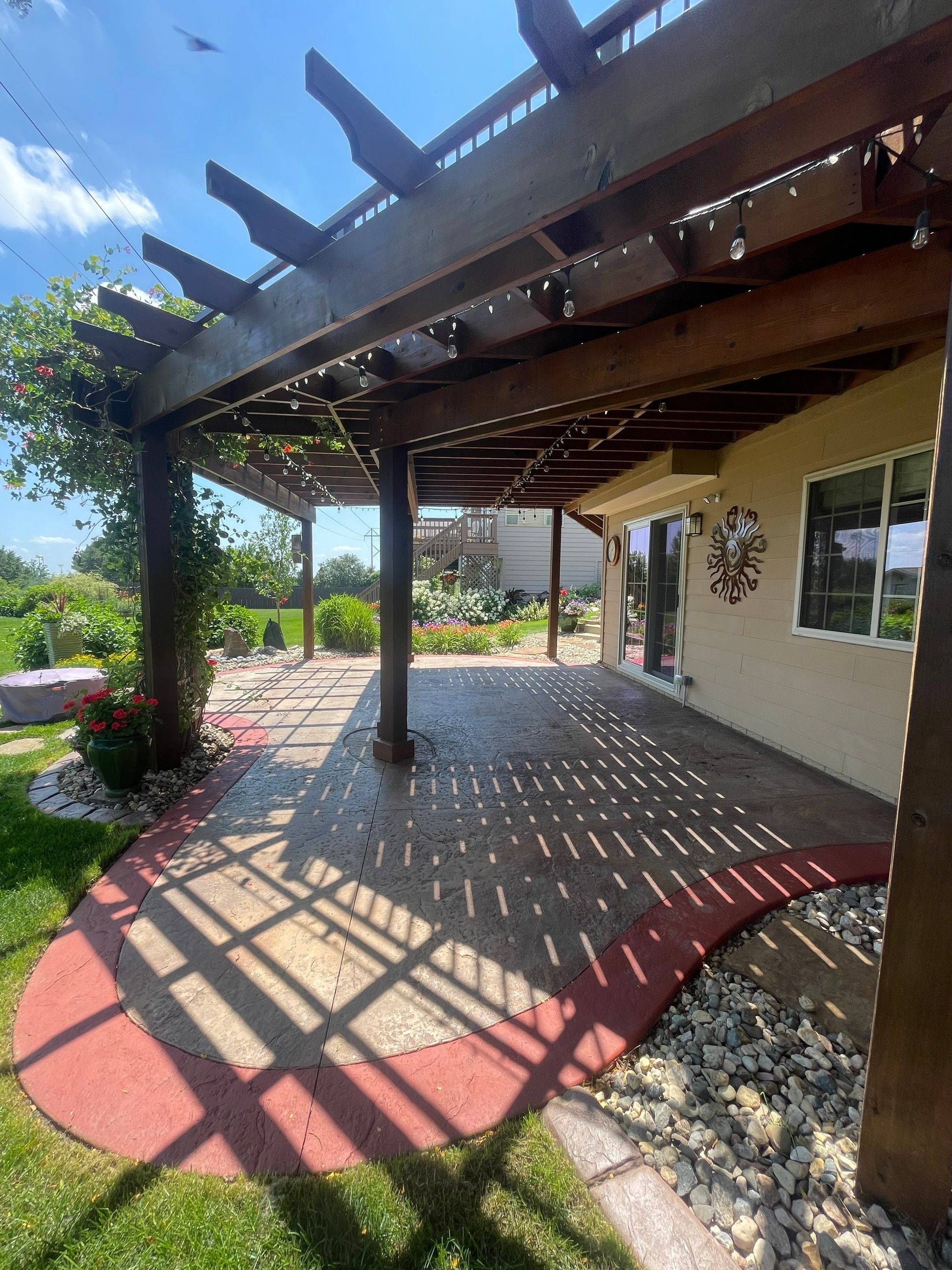 Custom Stamped Concrete Patio and Wood Pergola in Sioux Falls by Select Painting, Coatings & Garage Cabinets