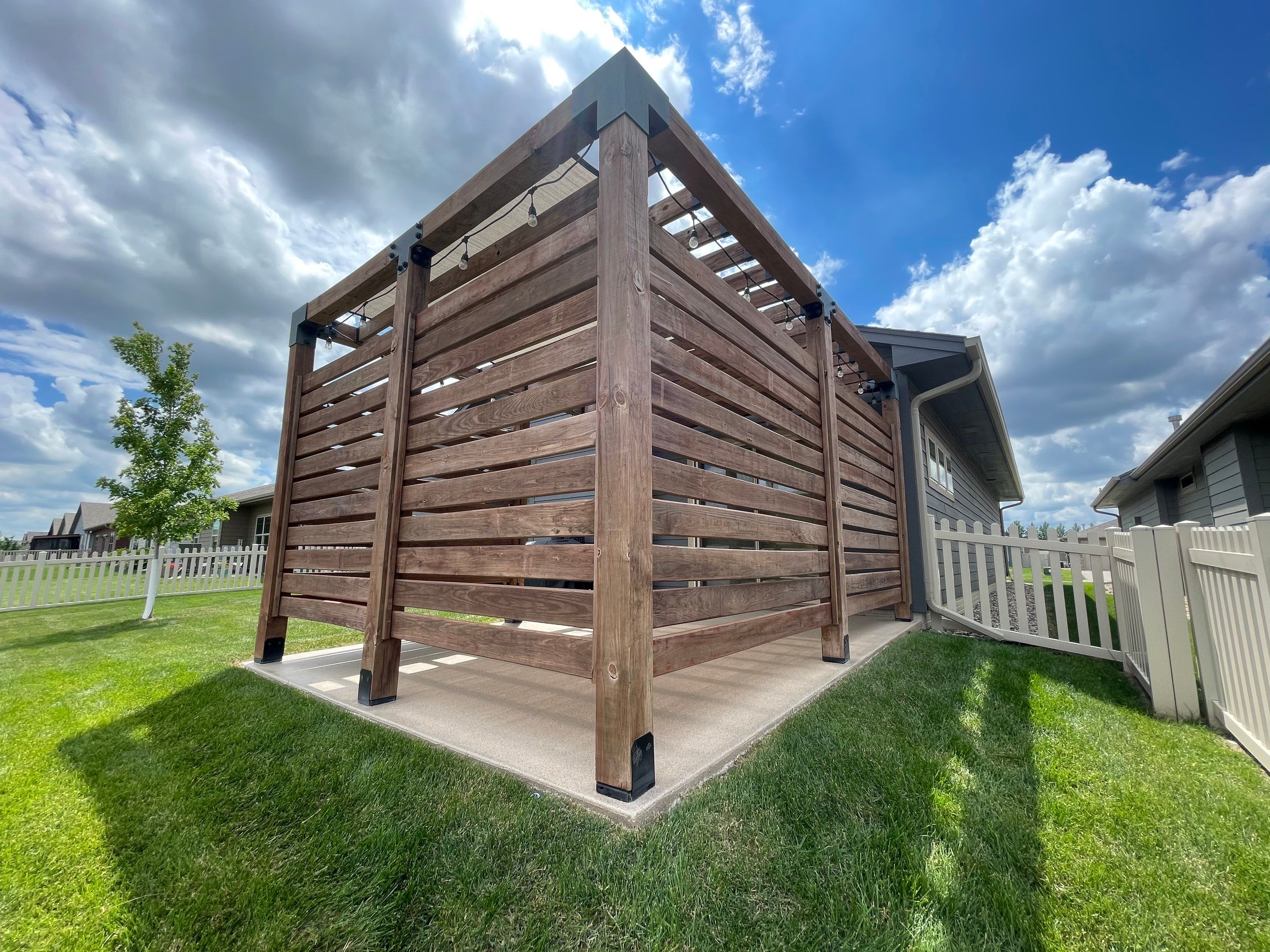 Textured Concrete Patio Coating and Custom Privacy Pergola in Sioux Falls by Select Painting, Coatings & Garage Cabinets