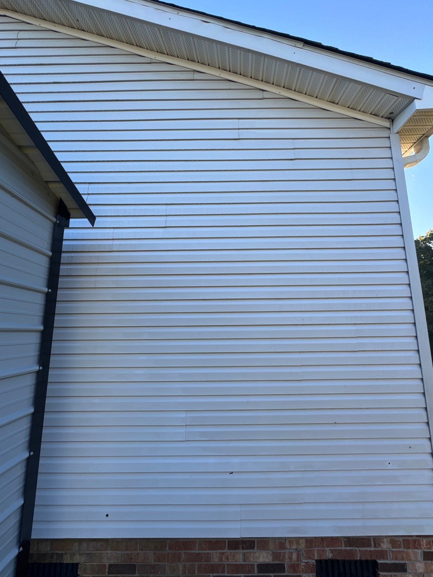 the service shown is cleaning the exterior vinyl siding of a house using a pressure washing technique