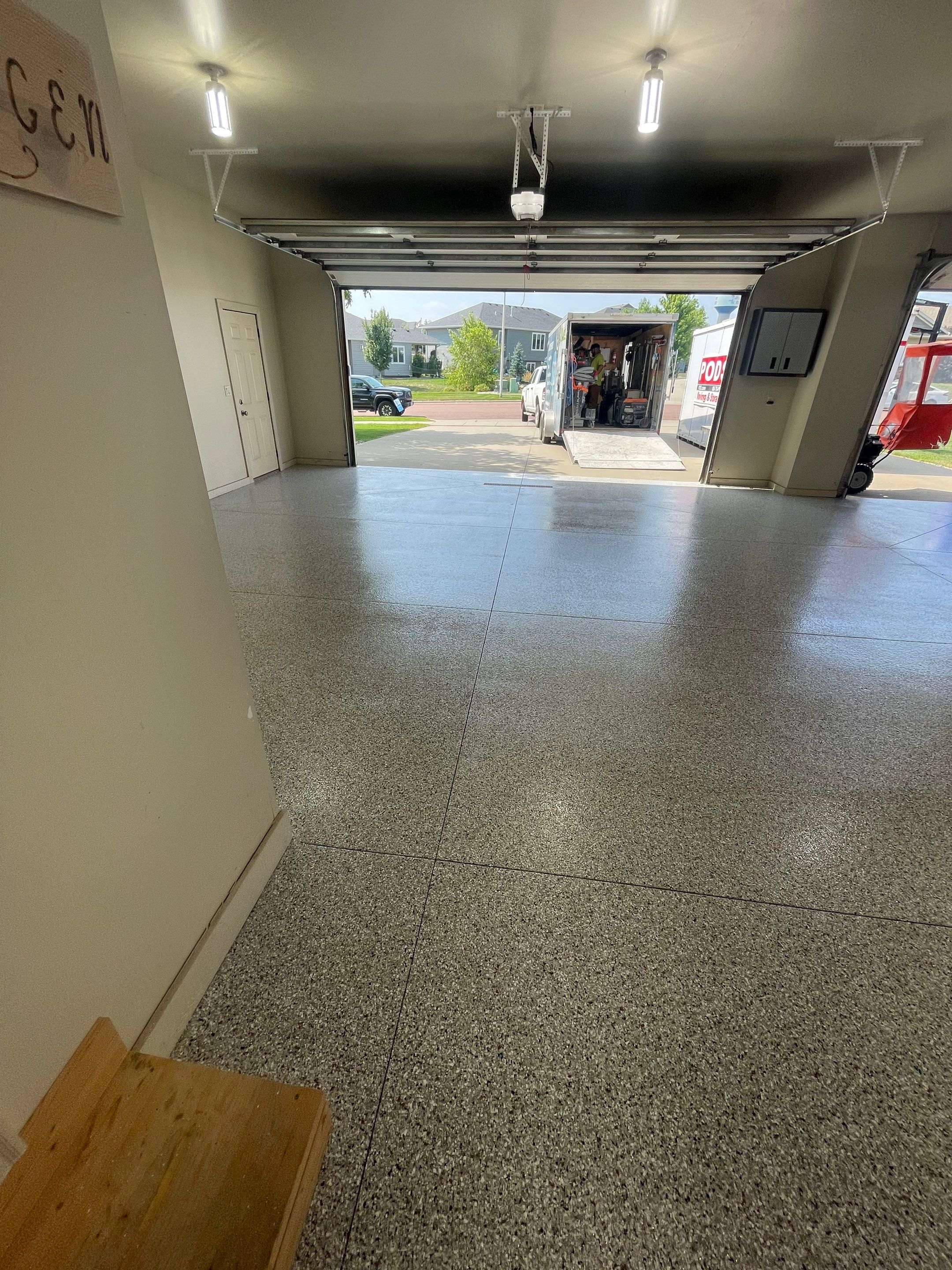 Coyote Flake Garage Floor Coating in Sioux Falls with Trench Drain by Select Painting, Coatings & Garage Cabinets
