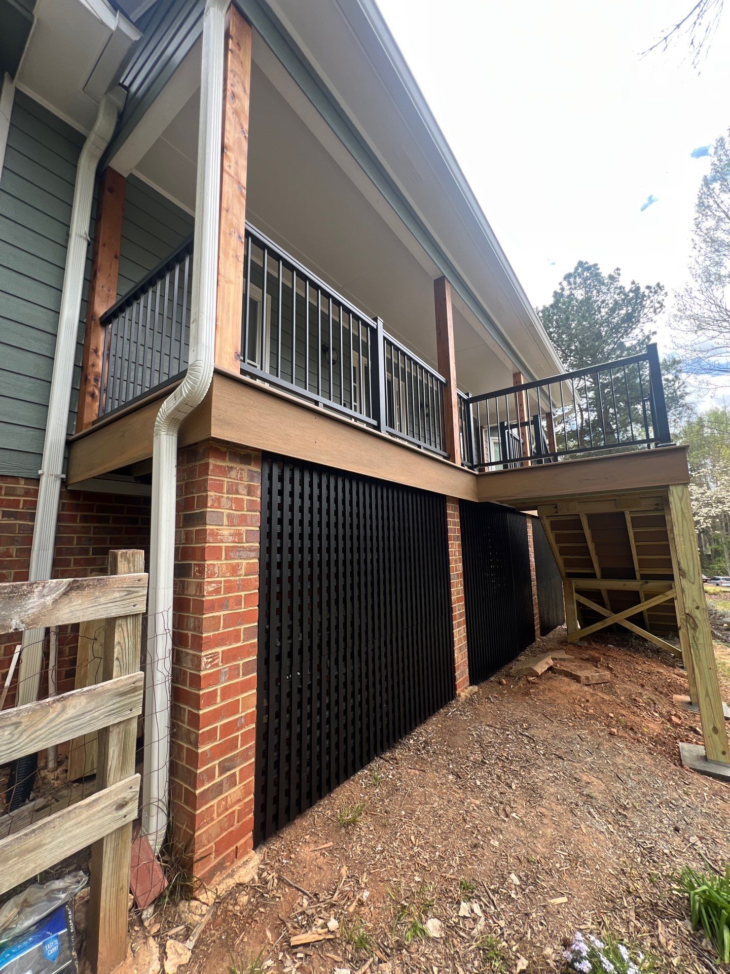 Composite Deck and Porch Renovation With Black Metal Railings by Swift Home Renovations 